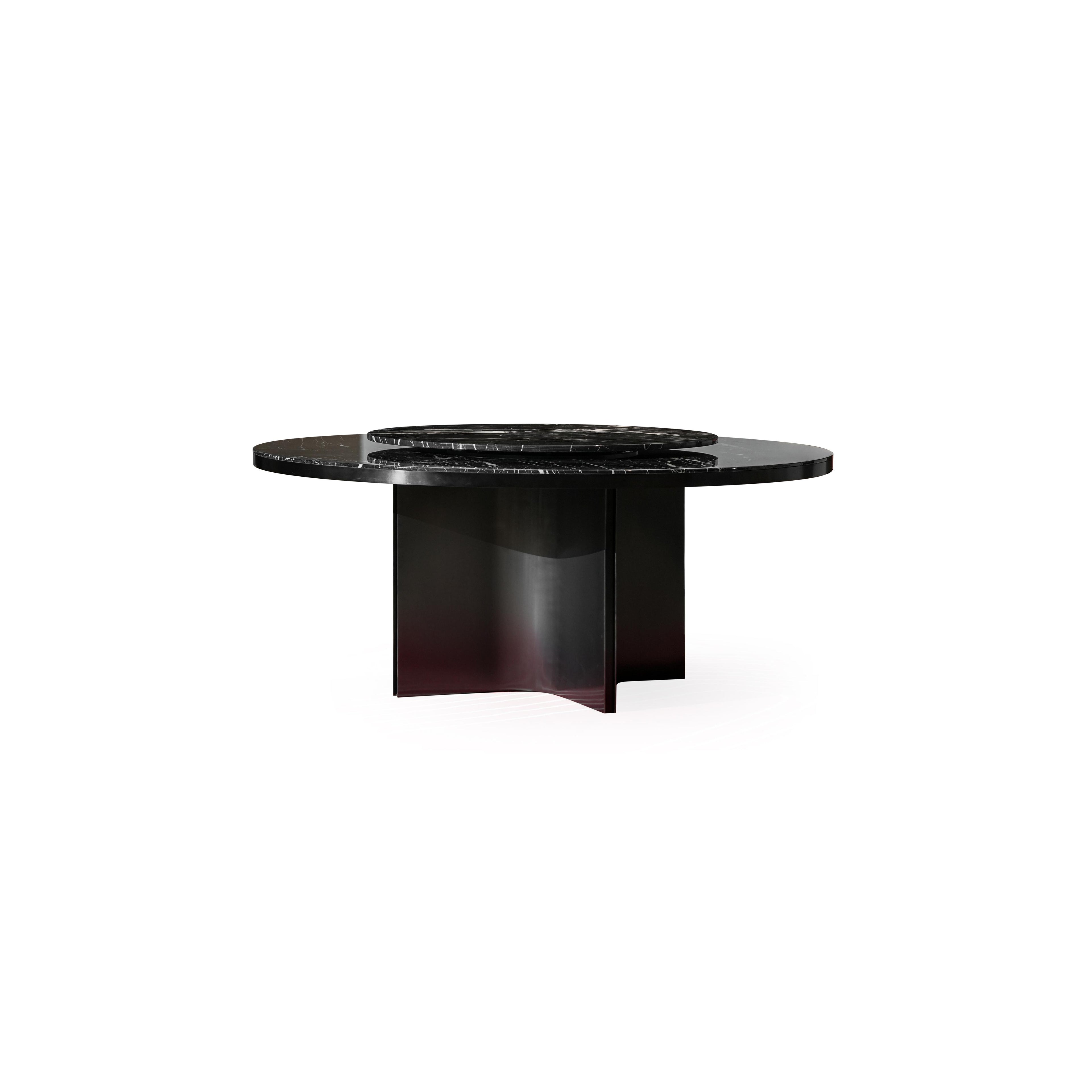 Round dining table with dark gray marble top and matte black metal base featuring three curved legs. Smooth, polished surface with natural veining. Structurally supported by central pillar and side supports. Intended for dining or serving. Category: furniture/dining-tables