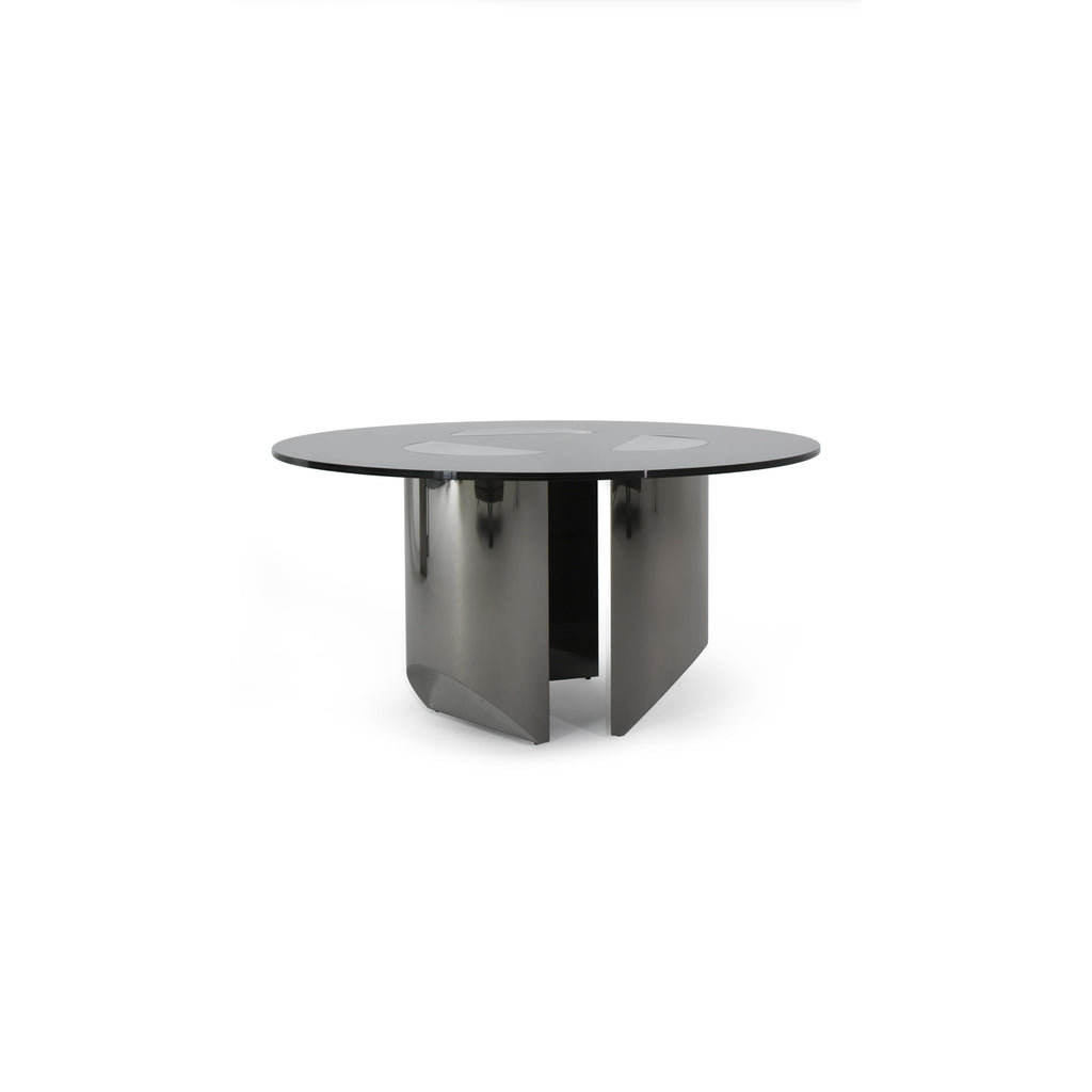 Round dining table with black glass top and dark metallic base featuring four angular legs. Table has three circular cutouts on the surface. Intended for dining or seating. Category: furniture/dining-tables