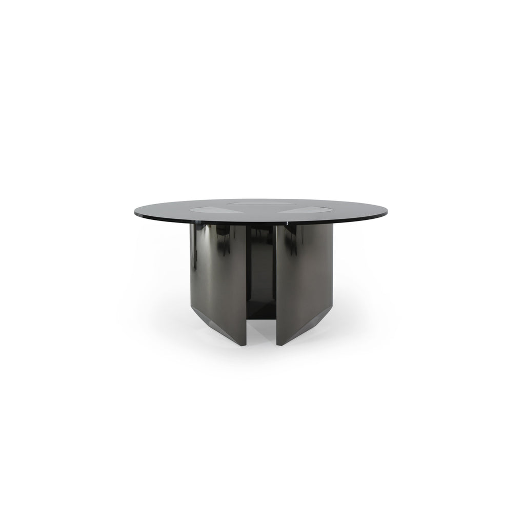 Round dining table with black glass top and dark metallic base featuring four angular legs. Table has three circular cutouts on the surface. Intended for dining or seating. Category: furniture/dining-tables