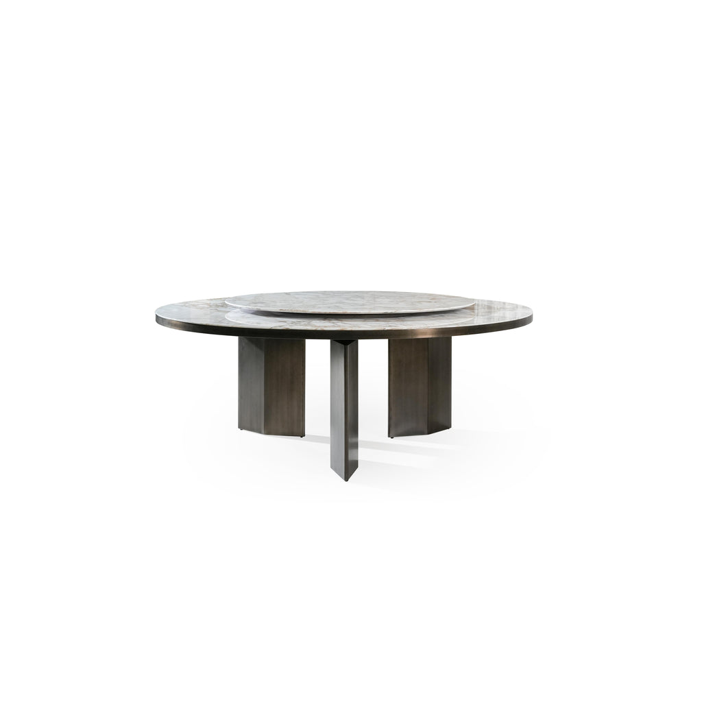 Round dining table with a marble top and dark metal legs, featuring a central rotating tray. The table has three thick, rectangular legs supporting a flat, circular surface. Category: furniture/dining-tables