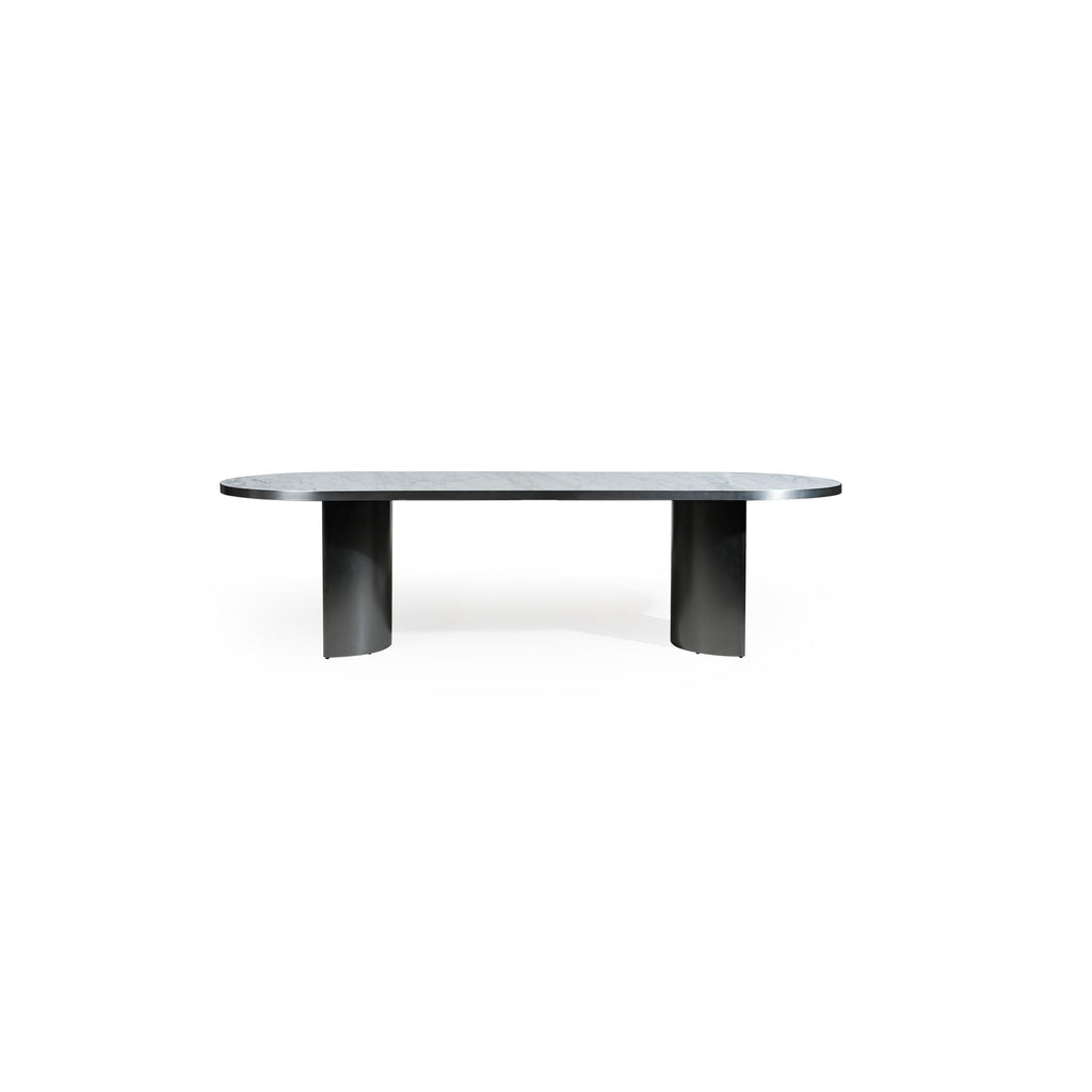 Modern oval dining table with a smooth, light gray stone top and two cylindrical black metal legs. Sleek, minimalist design supports flat surface for dining or work. Category: furniture/dining-tables