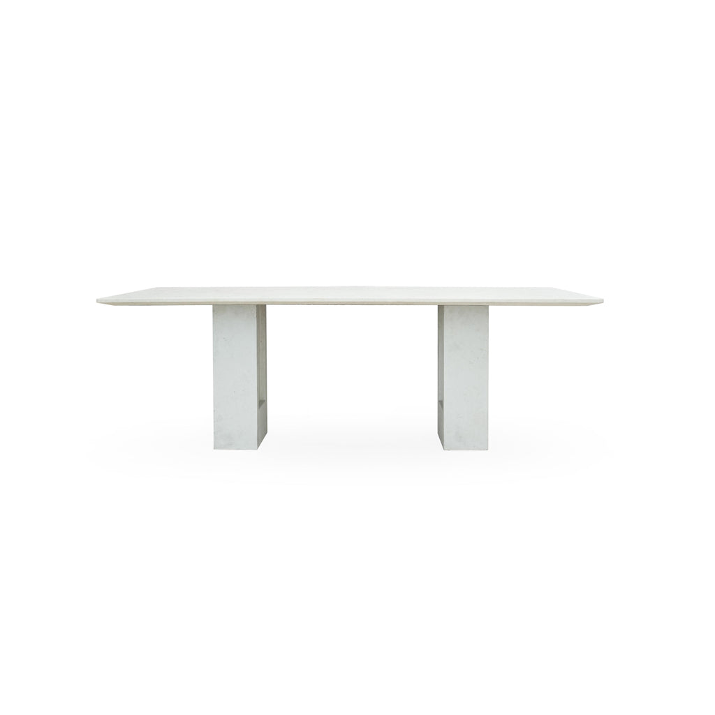 Rectangular glass tabletop supported by two marble bases with vertical grooves and metallic connectors, designed for dining or display, featuring a smooth, polished surface and natural stone texture. Category: Furniture > Tables > Dining Tables