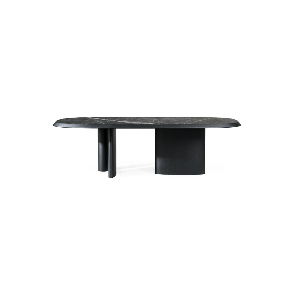 Modern coffee table with oval top and light wood finish, supported by two cylindrical legs and a central pedestal base; top surface has subtle wood grain texture; designed for placing items on a living room or lounge area; distinctively shaped with rounded edges and minimalistic structure. Category: furniture/coffee-tables