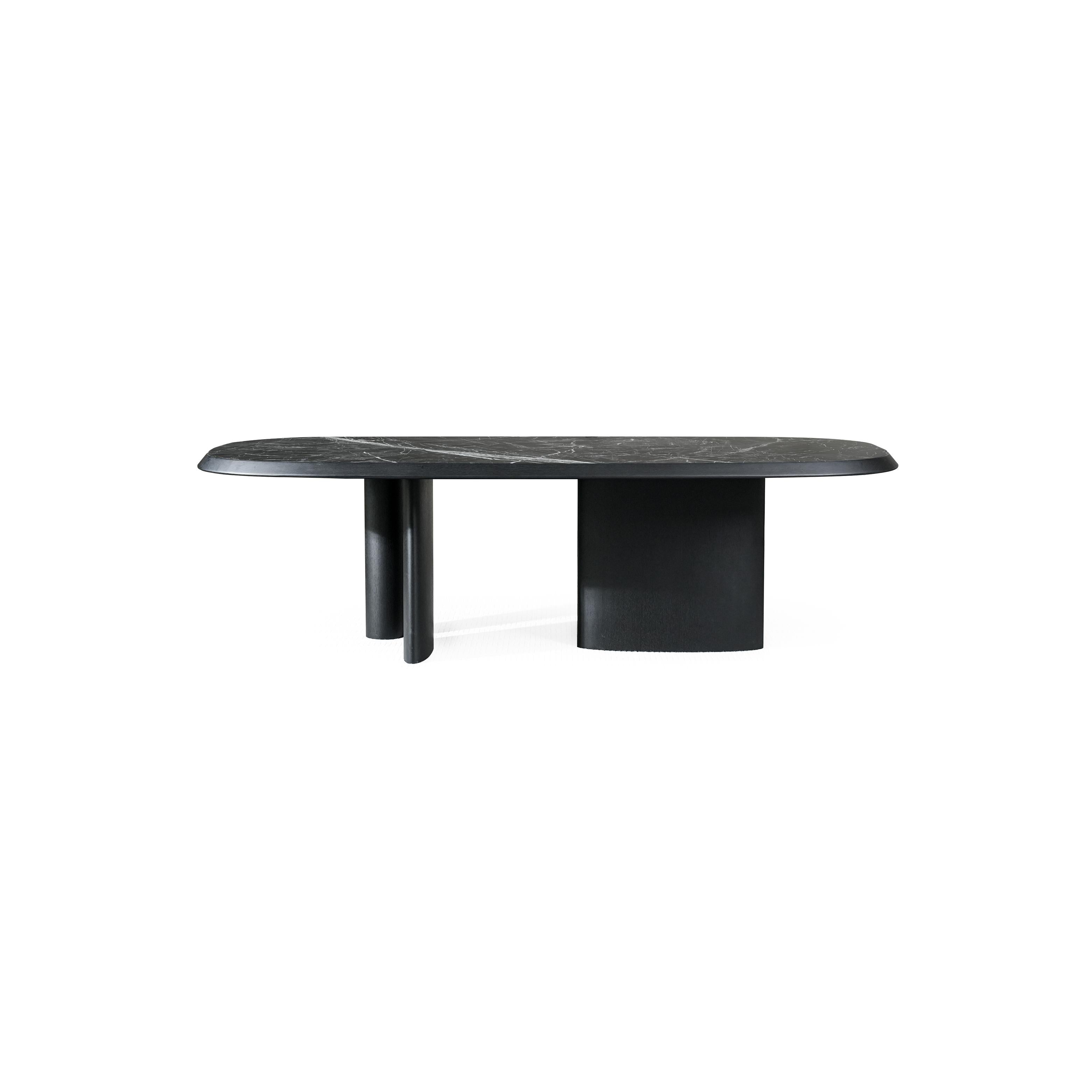 Modern coffee table with oval top and light wood finish, supported by two cylindrical legs and a central pedestal base; top surface has subtle wood grain texture; designed for placing items on a living room or lounge area; distinctively shaped with rounded edges and minimalistic structure. Category: furniture/coffee-tables