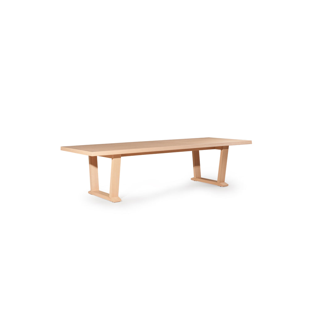 Long rectangular dining table with light wood finish, featuring two U-shaped legs supporting a flat tabletop; minimalistic design with no visible hardware or embellishments, intended for dining or workspace use; Category: furniture/dining-tables