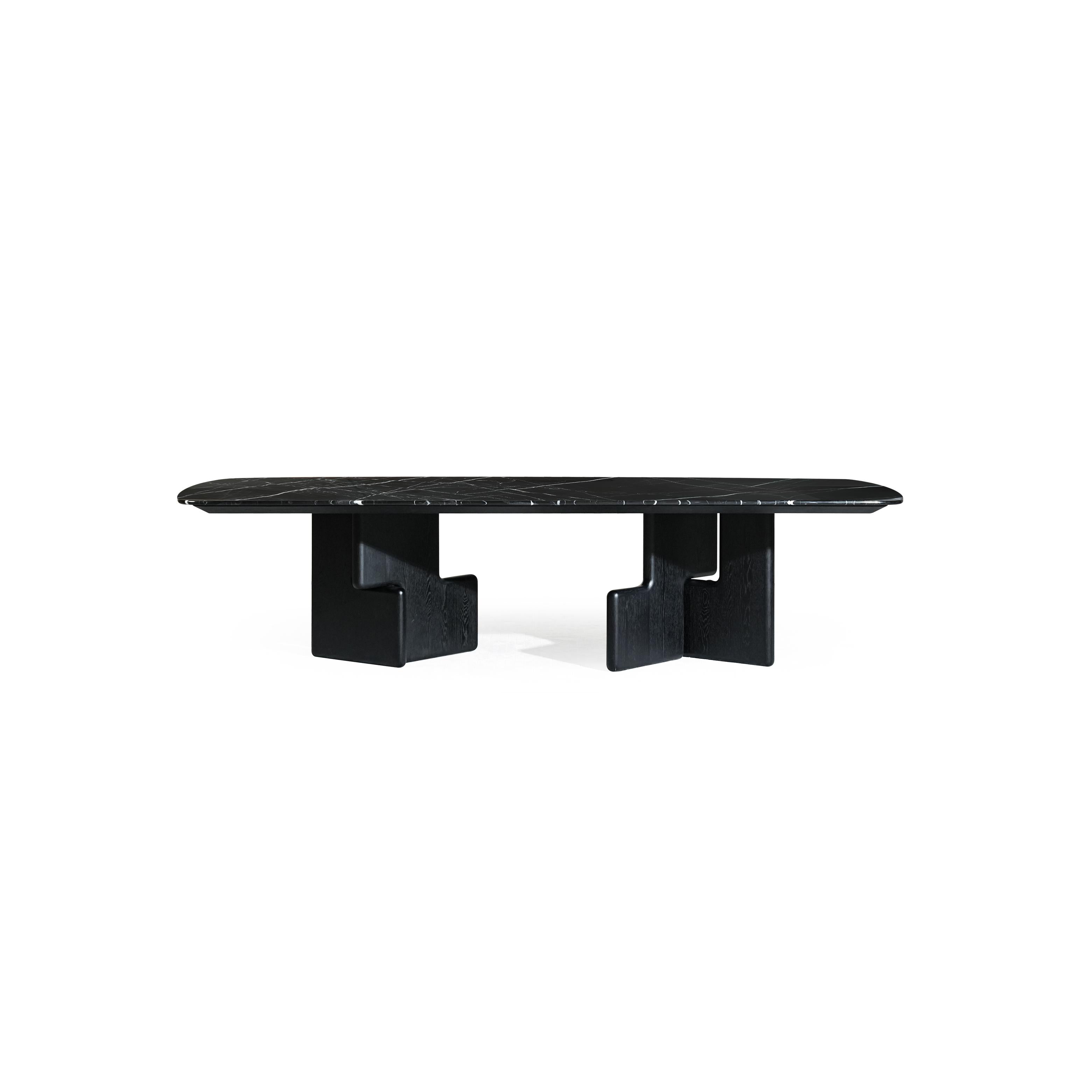 Modern rectangular dining table with black marble top and dark wood legs featuring angular, blocky supports. Table has smooth, flat surface with subtle veining. Intended for dining or serving. Category: furniture/dining-tables