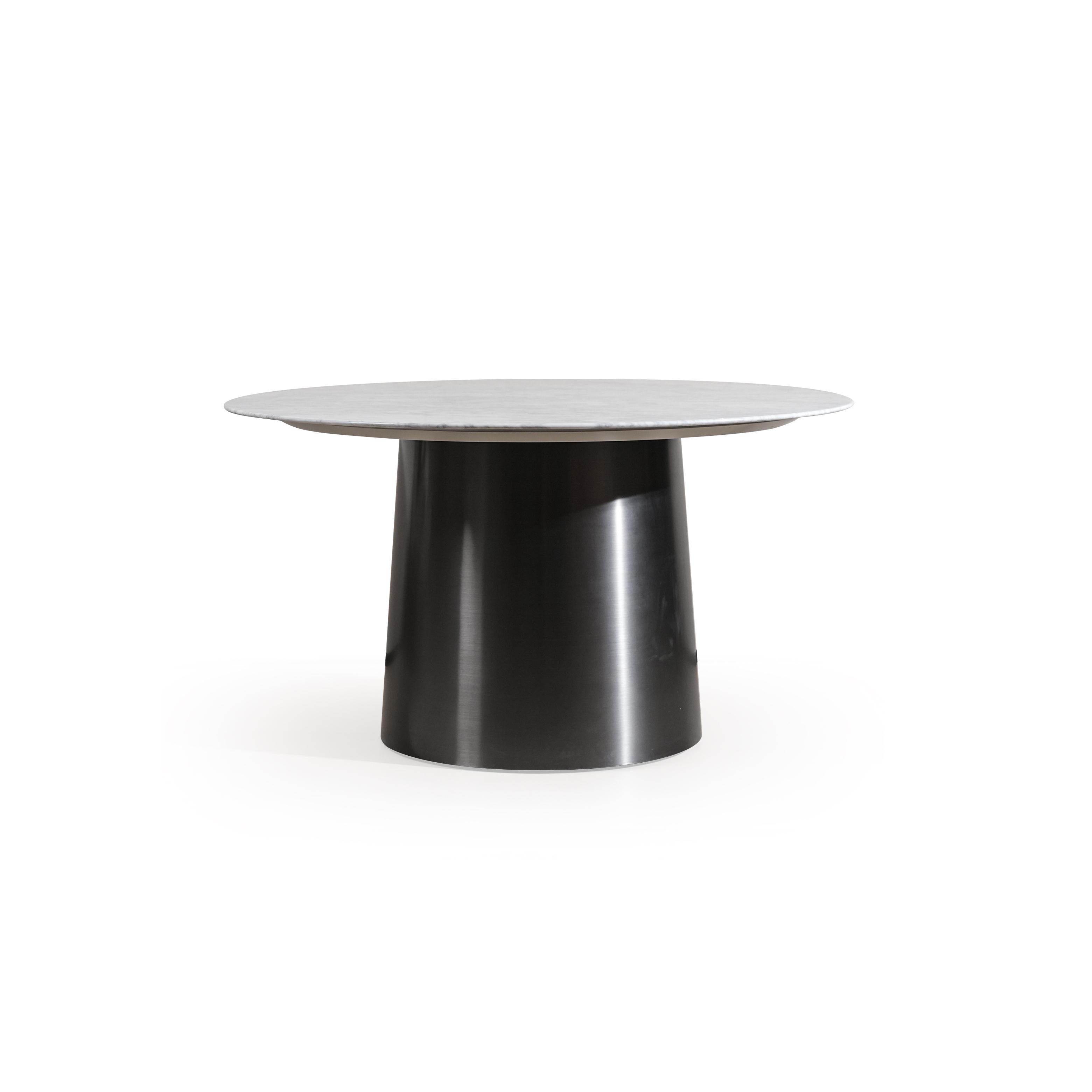 Round dining table with a marble top featuring light gray base and golden veining, supported by a cylindrical dark metal pedestal base. The table has a concentric circular design with a smaller circular inset on the surface. Intended for dining or serving. Category: furniture/dining-tables