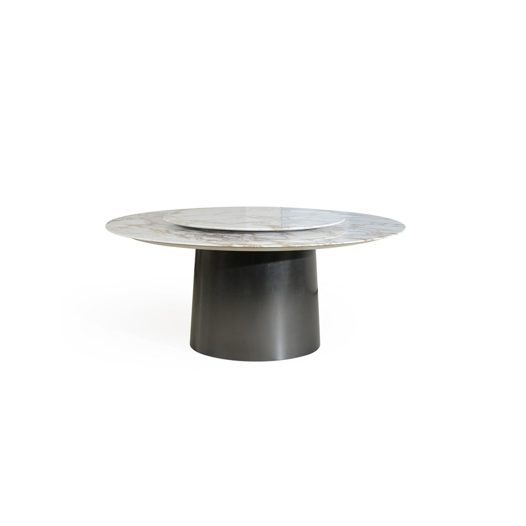 Round dining table with a marble top featuring light gray base and golden veining, supported by a cylindrical dark metal pedestal base. The table has a concentric circular design with a smaller circular inset on the surface. Intended for dining or serving. Category: furniture/dining-tables
