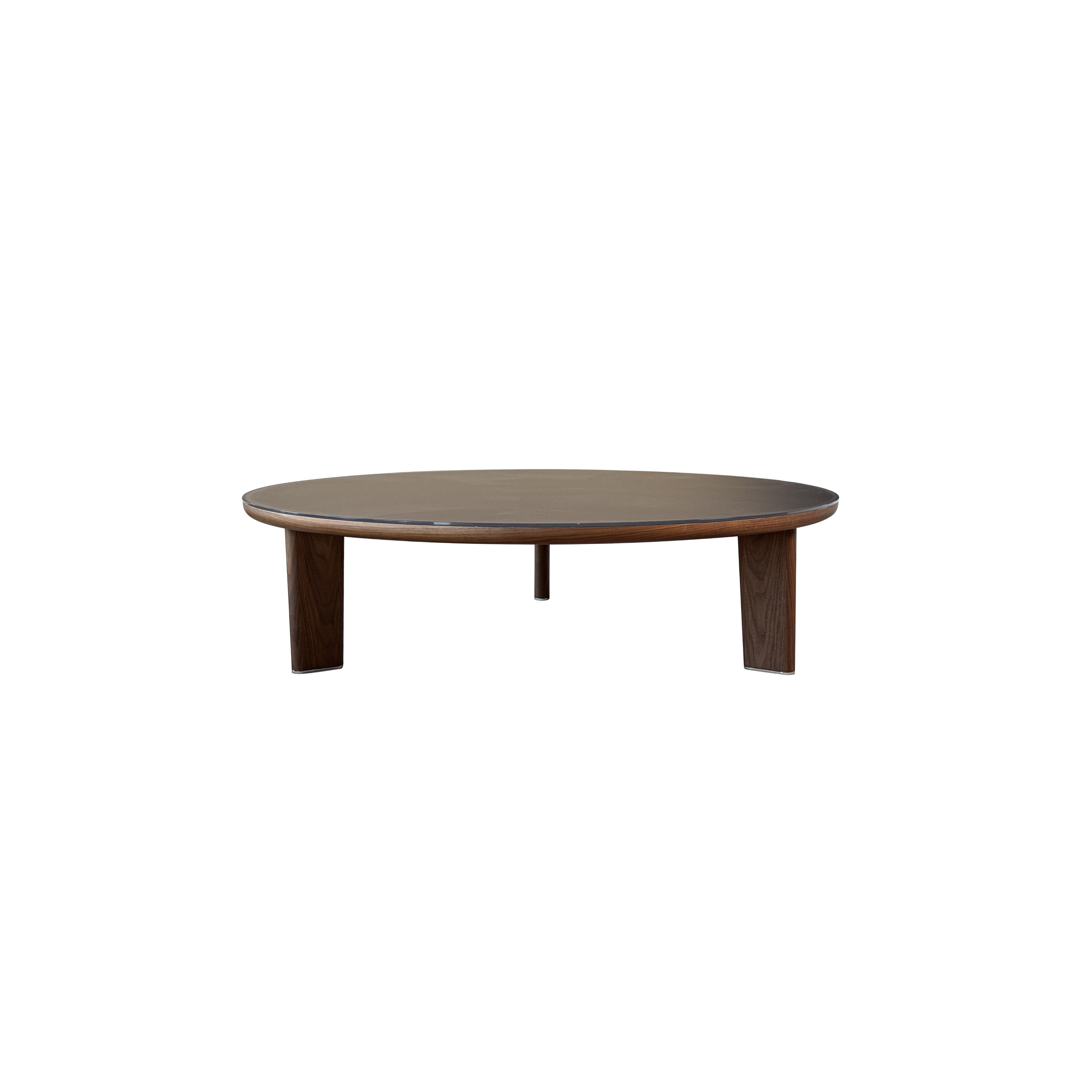 Round coffee table with dark wood legs and a smooth, dark-toned tabletop. Features three sturdy legs supporting a circular surface. Wood grain visible on legs. Intended for placing drinks or small items. Category: furniture/coffee-tables