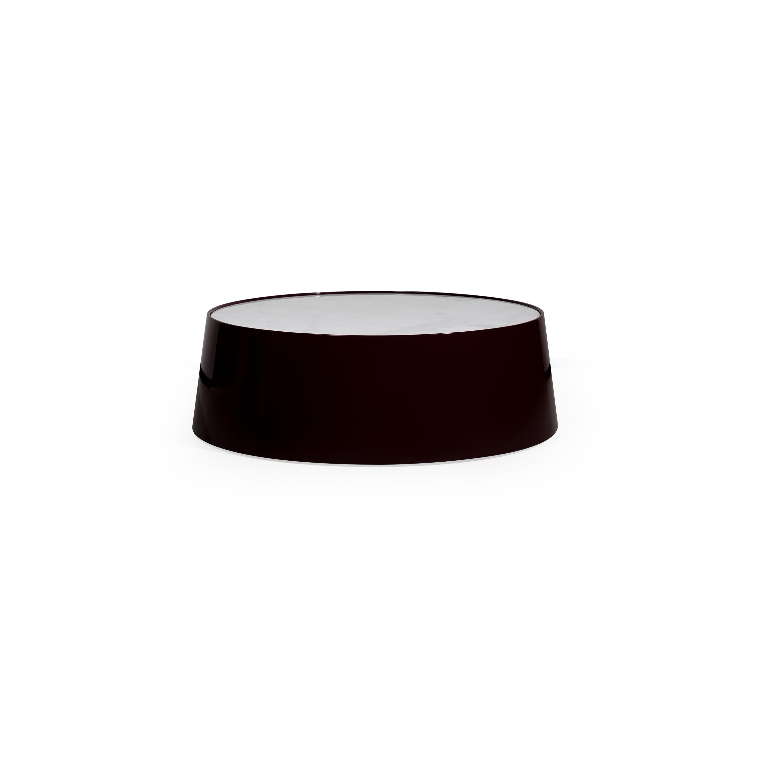 Round coffee table with a dark glossy finish base and a light-colored flat top surface. Features a solid, cylindrical structure with no visible legs or supports. Intended for placing items on a seating area. Category: furniture/coffee-tables