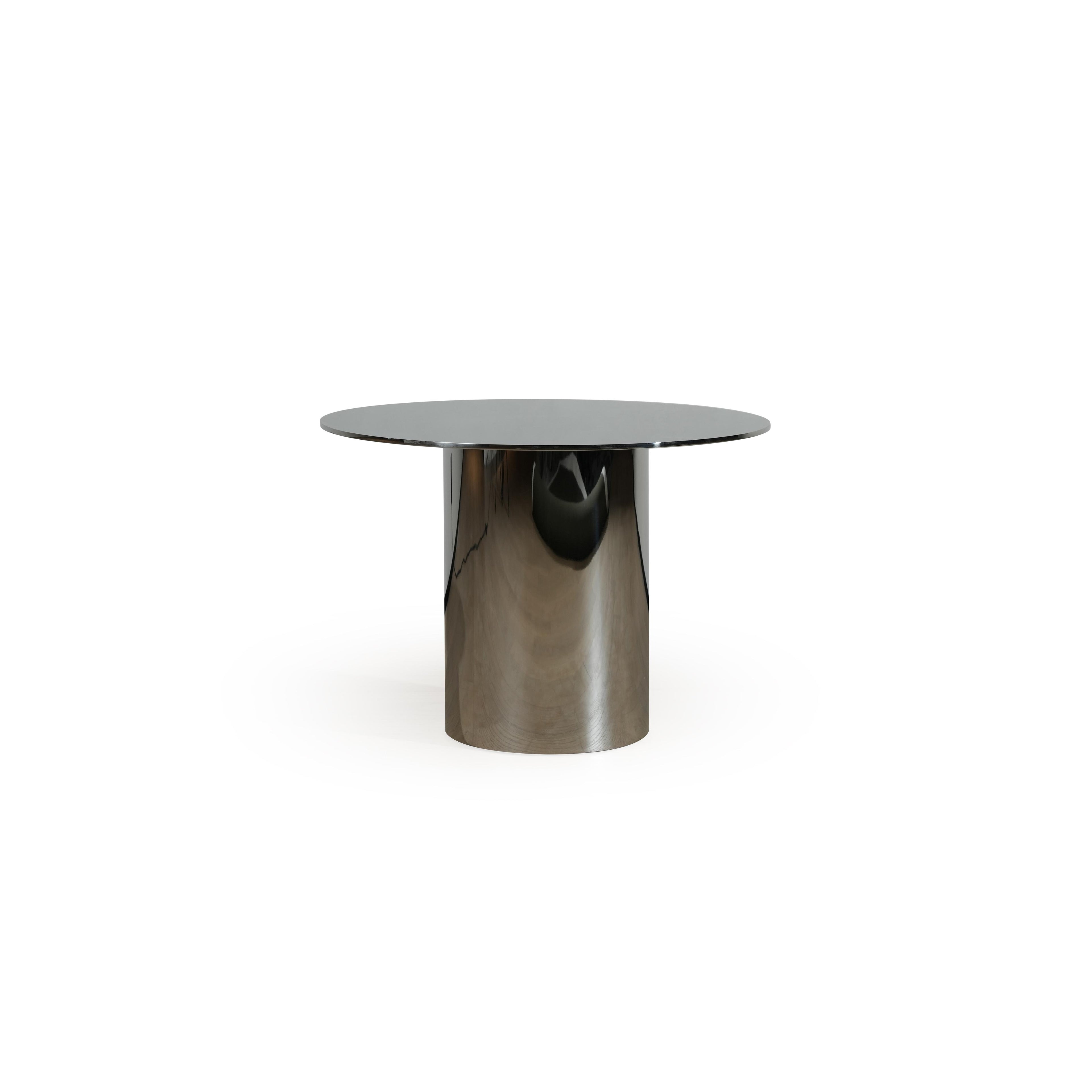 Round dining table with a dark, smooth tabletop and a single cylindrical metallic base. The base has a reflective, brushed metal finish. Intended for dining or serving. Category: furniture/dining-tables