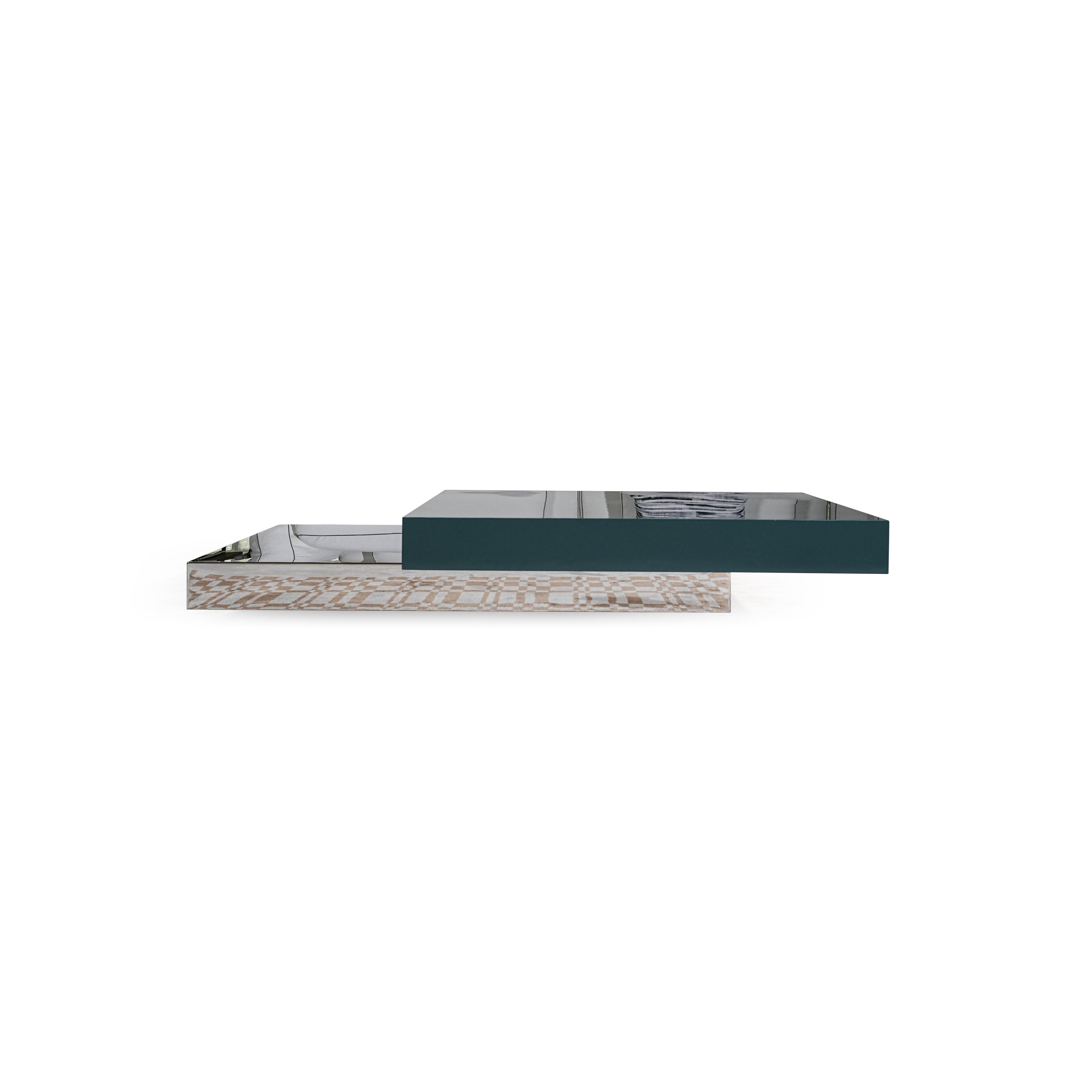 Modern rectangular coffee table with two tiers: lower tier has light wood-grain surface, upper tier is dark teal glossy finish. Features stacked, flat, rectangular surfaces with visible edges. Intended for placing items on a living room floor. Category: furniture/coffee-tables