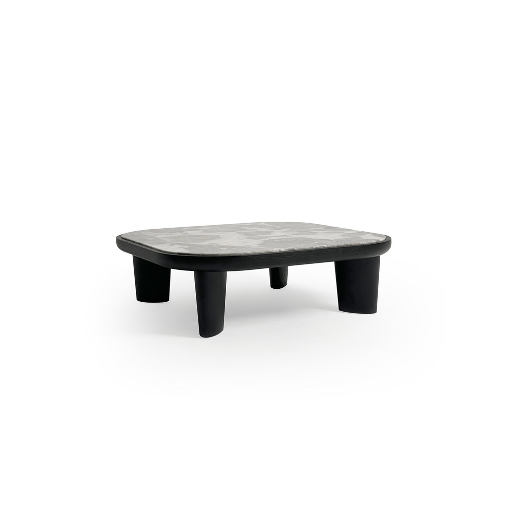 Low-profile coffee table with rounded rectangular top in light gray marble-like surface, supported by four thick, dark-stained wooden legs. Minimalist design for placing items on a flat surface. Category: furniture/coffee-tables