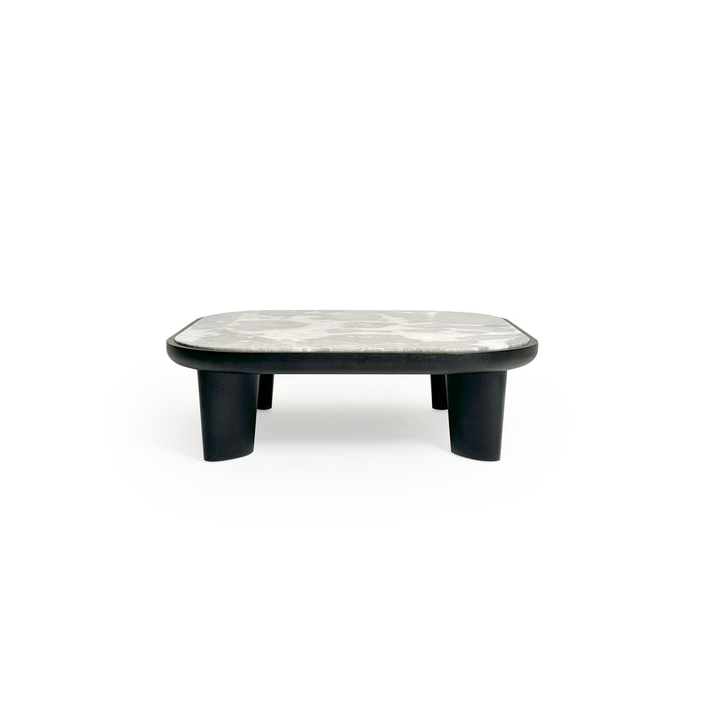 Low-profile coffee table with rounded rectangular top in light gray marble-like surface, supported by four thick, dark-stained wooden legs. Minimalist design for placing items on a flat surface. Category: furniture/coffee-tables