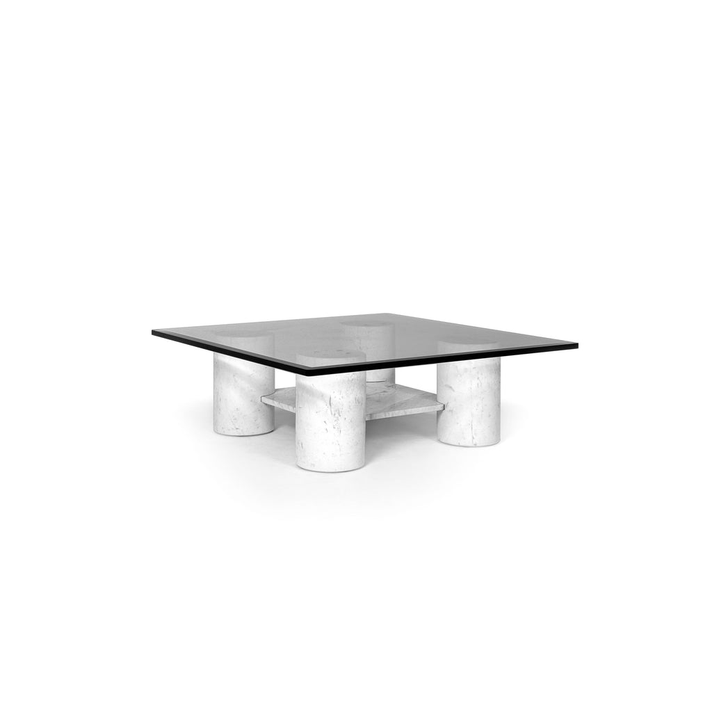 A square coffee table with a dark glass top supported by four cylindrical white stone legs, featuring a lower shelf made of matching stone, designed for placing items or serving drinks. Category: Furniture > Coffee Tables