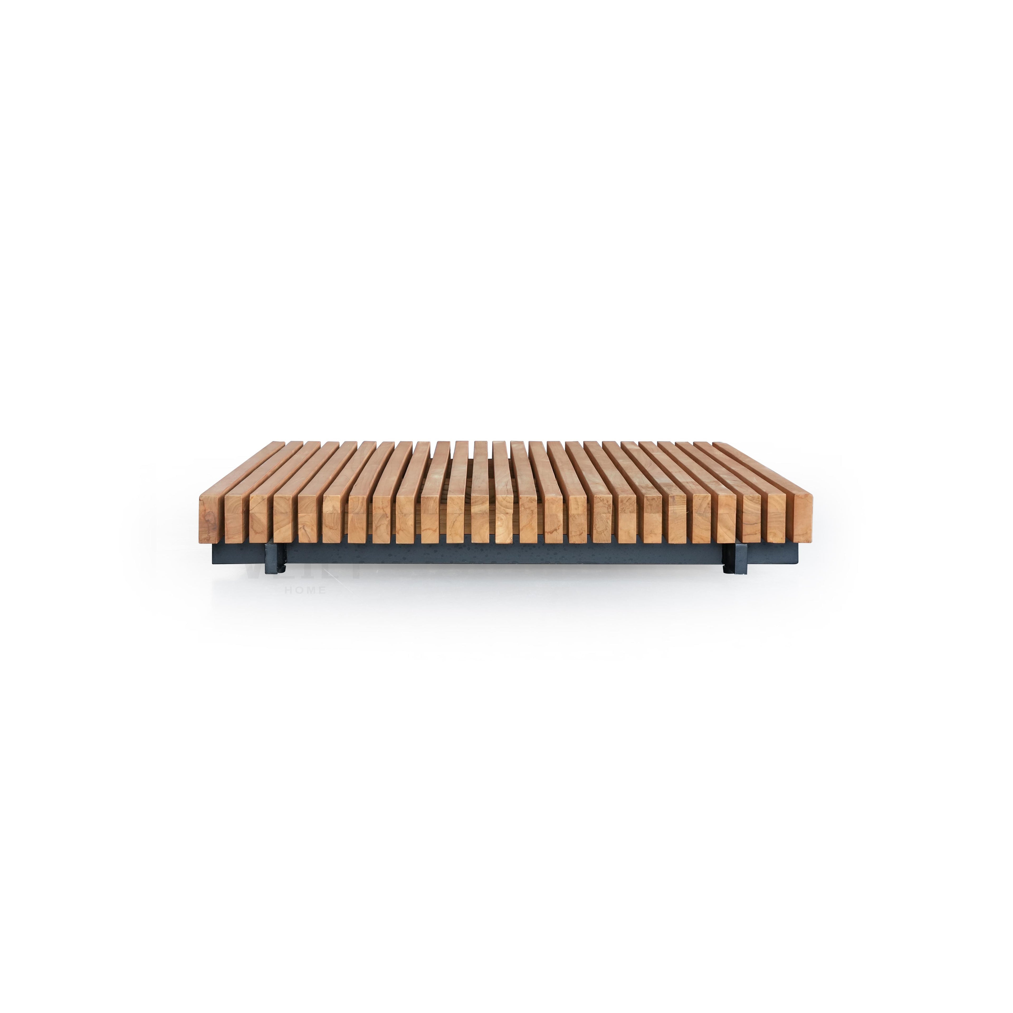 This is a low-profile bench with parallel wooden slats in a light brown finish resting on a dark gray metal frame. It has four short legs and a flat, rectangular form. The wood shows natural grain. Intended for seating in outdoor or indoor spaces. Category: Furniture > Outdoor Furniture > Benches