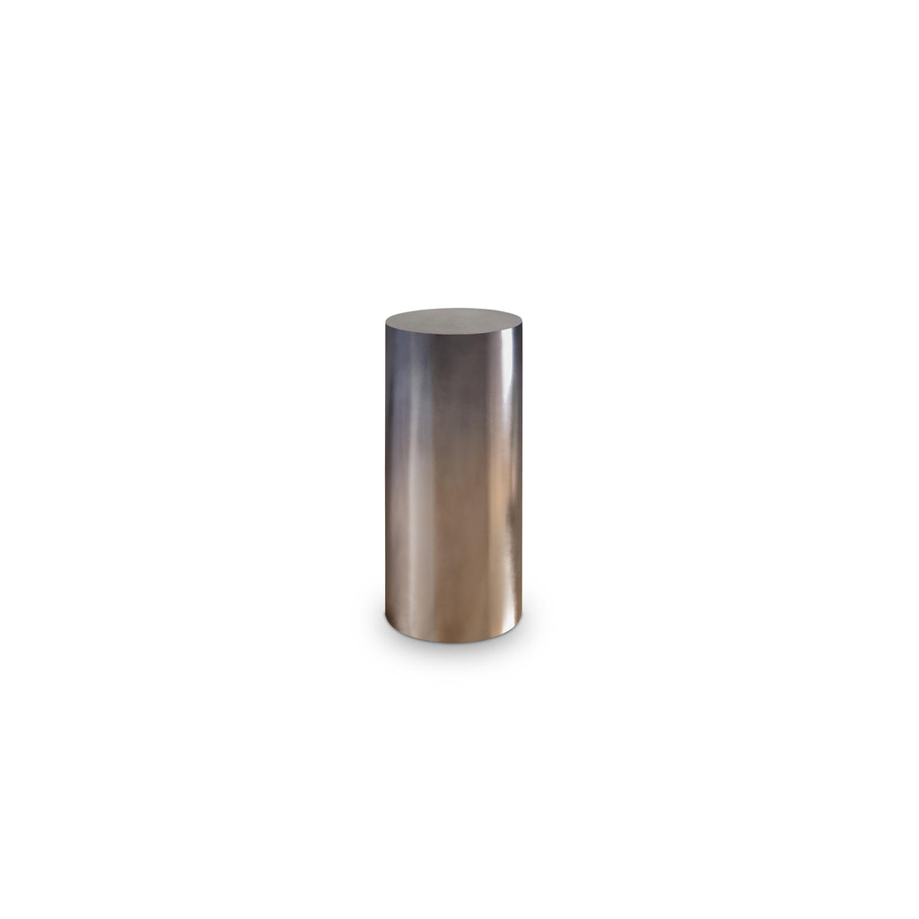 This is a cylindrical side table with a smooth, metallic finish that transitions from silver to bronze. It has no legs, arms, or handles. Its solid, vertical form suggests it’s meant for holding small items. Category: furniture/side-tables