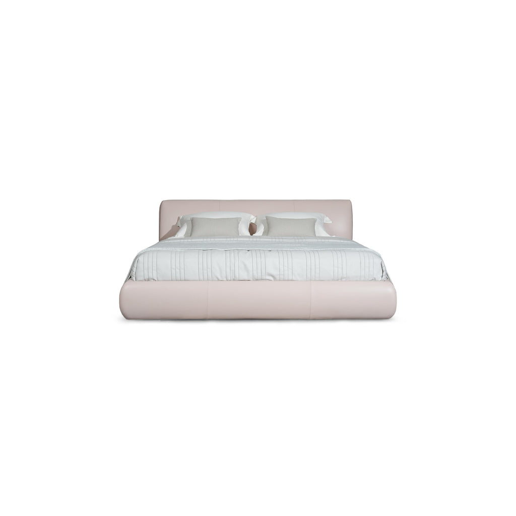 Low-profile platform bed with upholstered headboard and base in muted taupe fabric. Features padded cushions, subtle stitching, and short black legs. Designed for sleeping, with two white pillows and a light gray throw blanket. Category: furniture > beds > platform beds