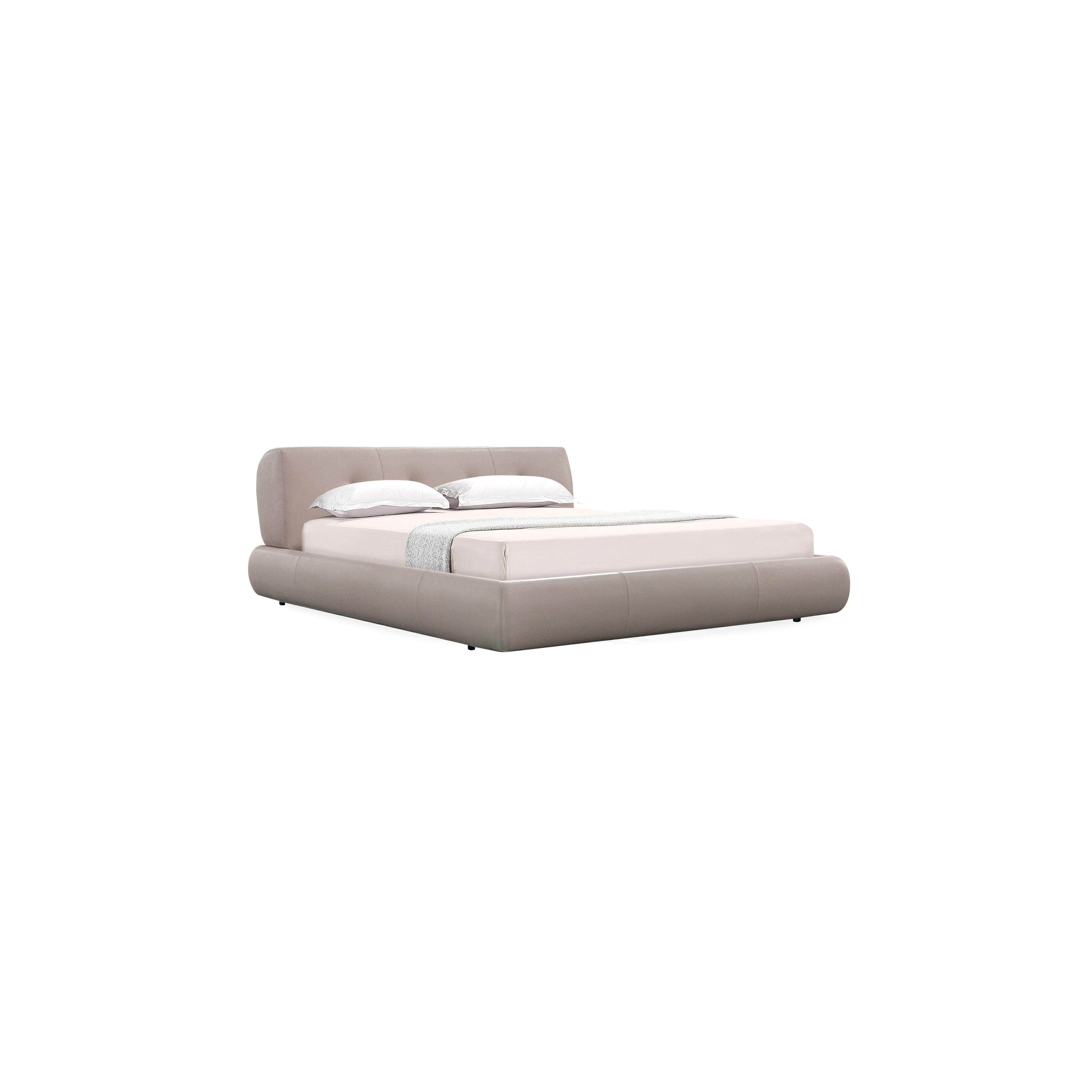 Low-profile platform bed with upholstered headboard and base in muted taupe fabric. Features padded cushions, subtle stitching, and short black legs. Designed for sleeping, with two white pillows and a light gray throw blanket. Category: furniture > beds > platform beds