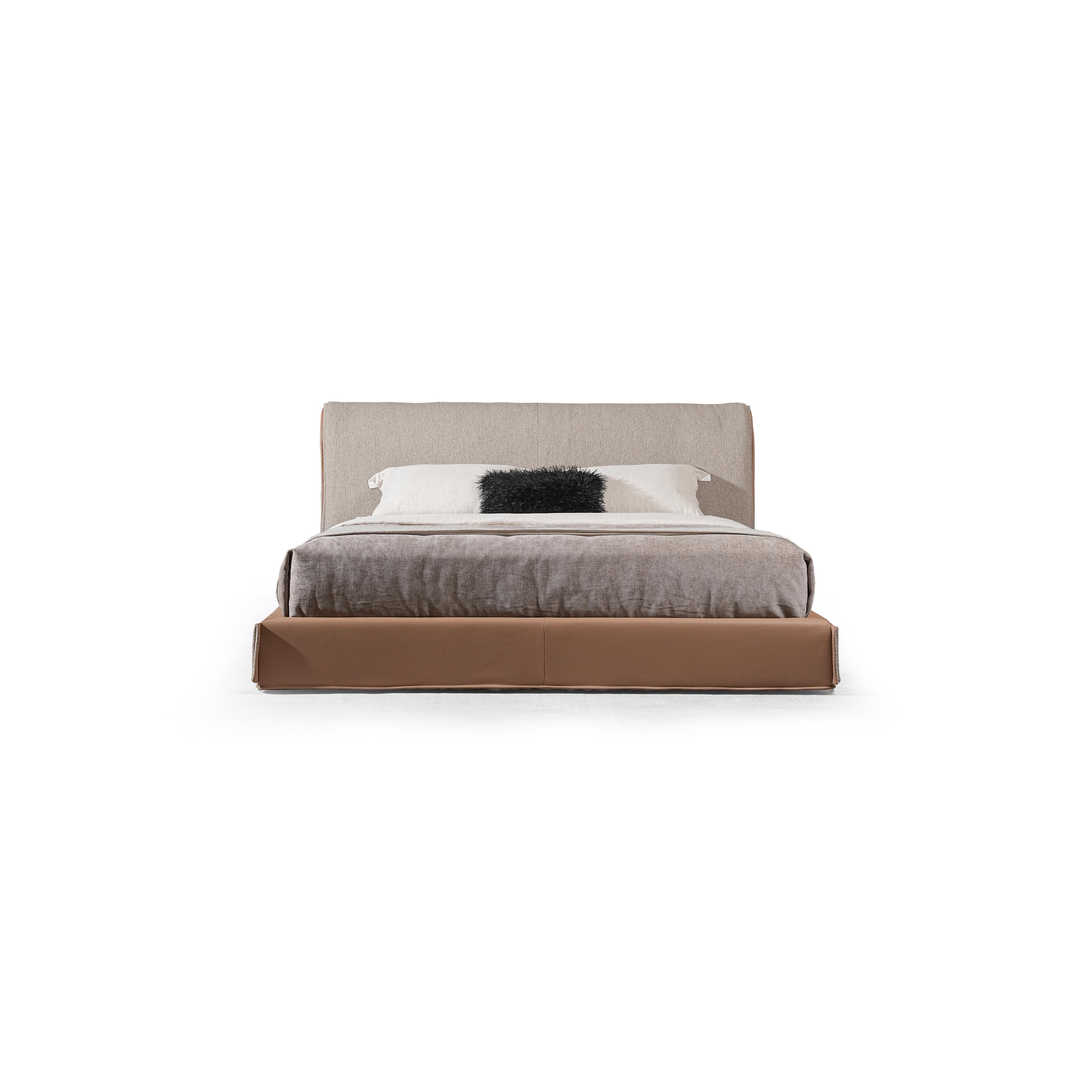 Low-profile bed with upholstered headboard and base, featuring beige fabric headboard, brown base, gray textured comforter, and white pillow with black furry accent; designed for sleeping, with clean lines and visible seam stitching. Category: furniture > beds > platform beds