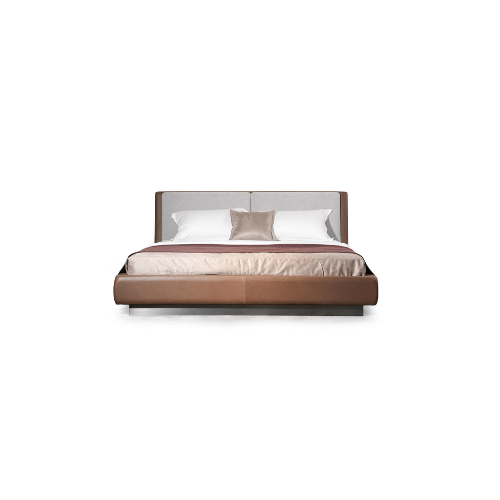 Modern platform bed with a two-tone upholstered headboard and base; brown leather-like material on sides and base, gray fabric on headboard; low-profile metal legs; white and beige bedding with a maroon throw; stitched seams visible; designed for sleeping; Category: Furniture > Beds > Platform Beds