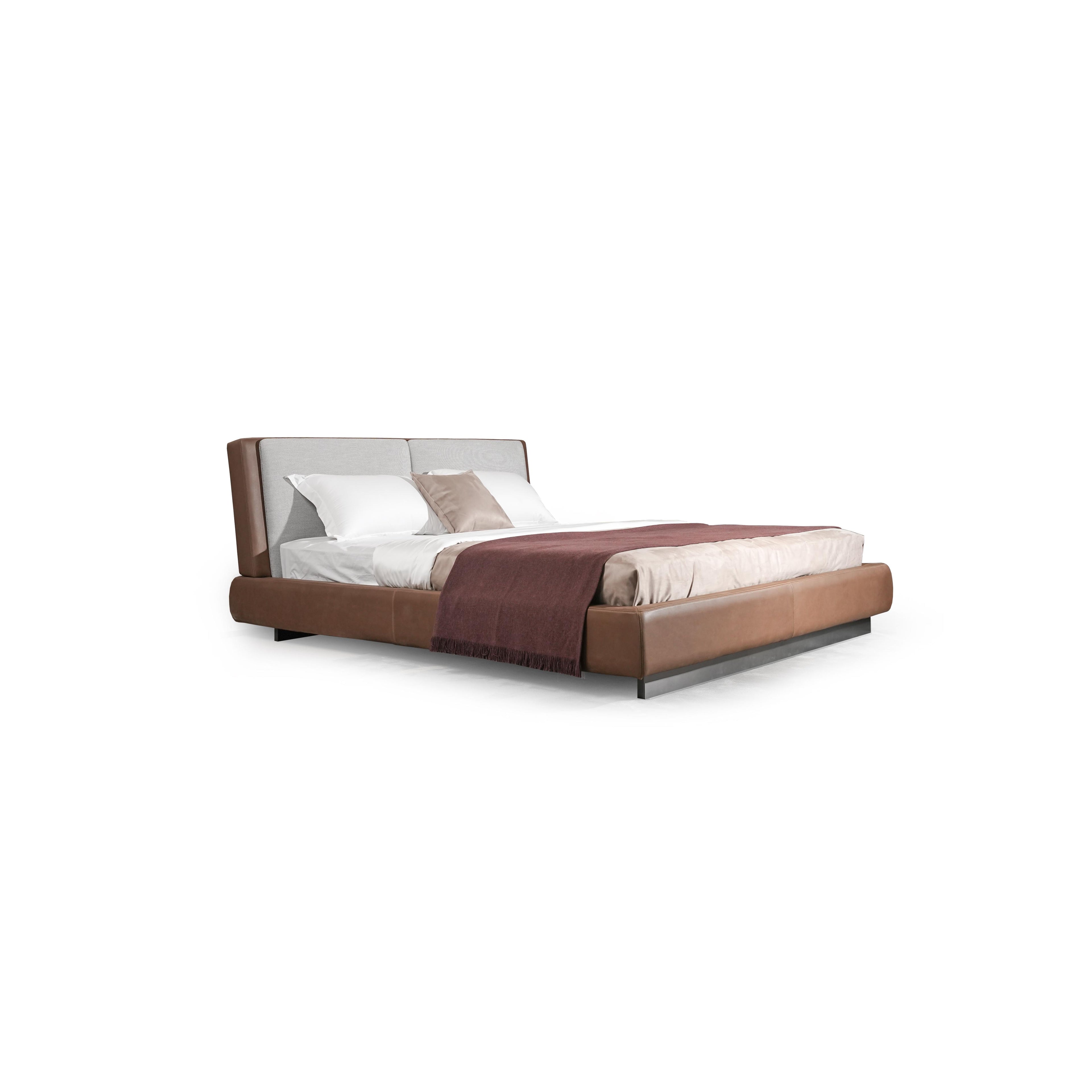 Modern platform bed with a two-tone upholstered headboard and base; brown leather-like material on sides and base, gray fabric on headboard; low-profile metal legs; white and beige bedding with a maroon throw; stitched seams visible; designed for sleeping; Category: Furniture > Beds > Platform Beds