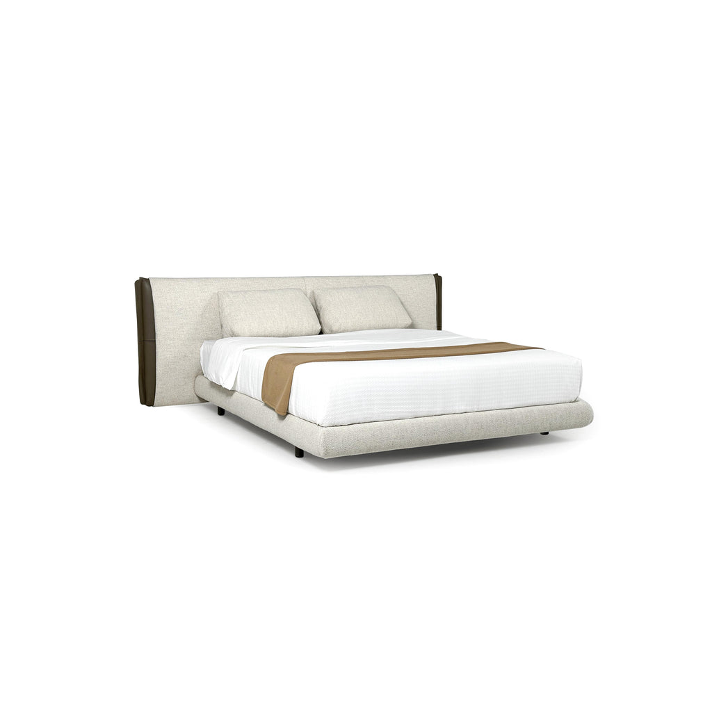 This is a upholstered bed with a low-profile frame and a padded headboard. It features two matching pillows, a white mattress cover, and a tan throw blanket. The headboard and base are covered in a textured fabric with dark brown vertical accents. The bed has four short, dark legs. Category: furniture > beds > upholstered beds
