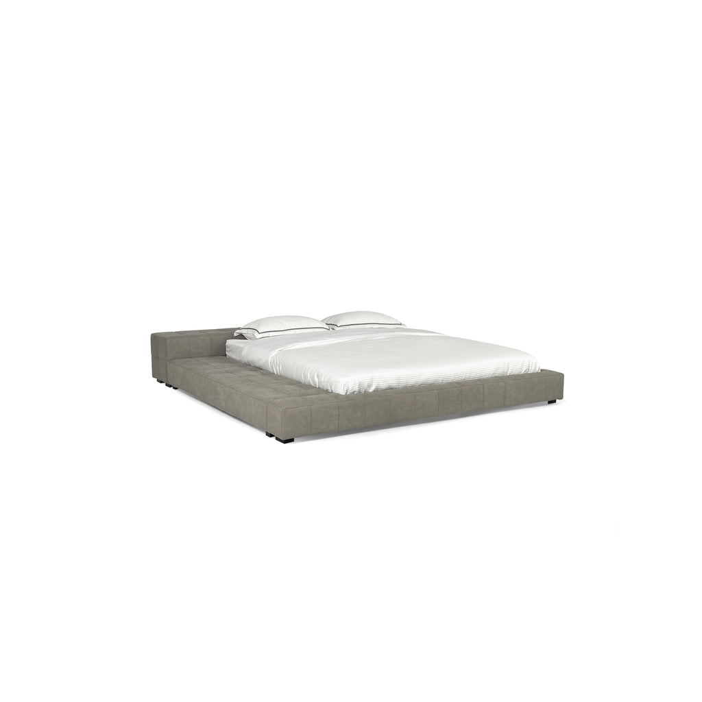 Low-profile platform bed with tufted gray upholstered frame, two matching pillows, and white bedding; features short black legs and continuous cushioned base; designed for sleeping; Category: Furniture > Beds > Platform Beds