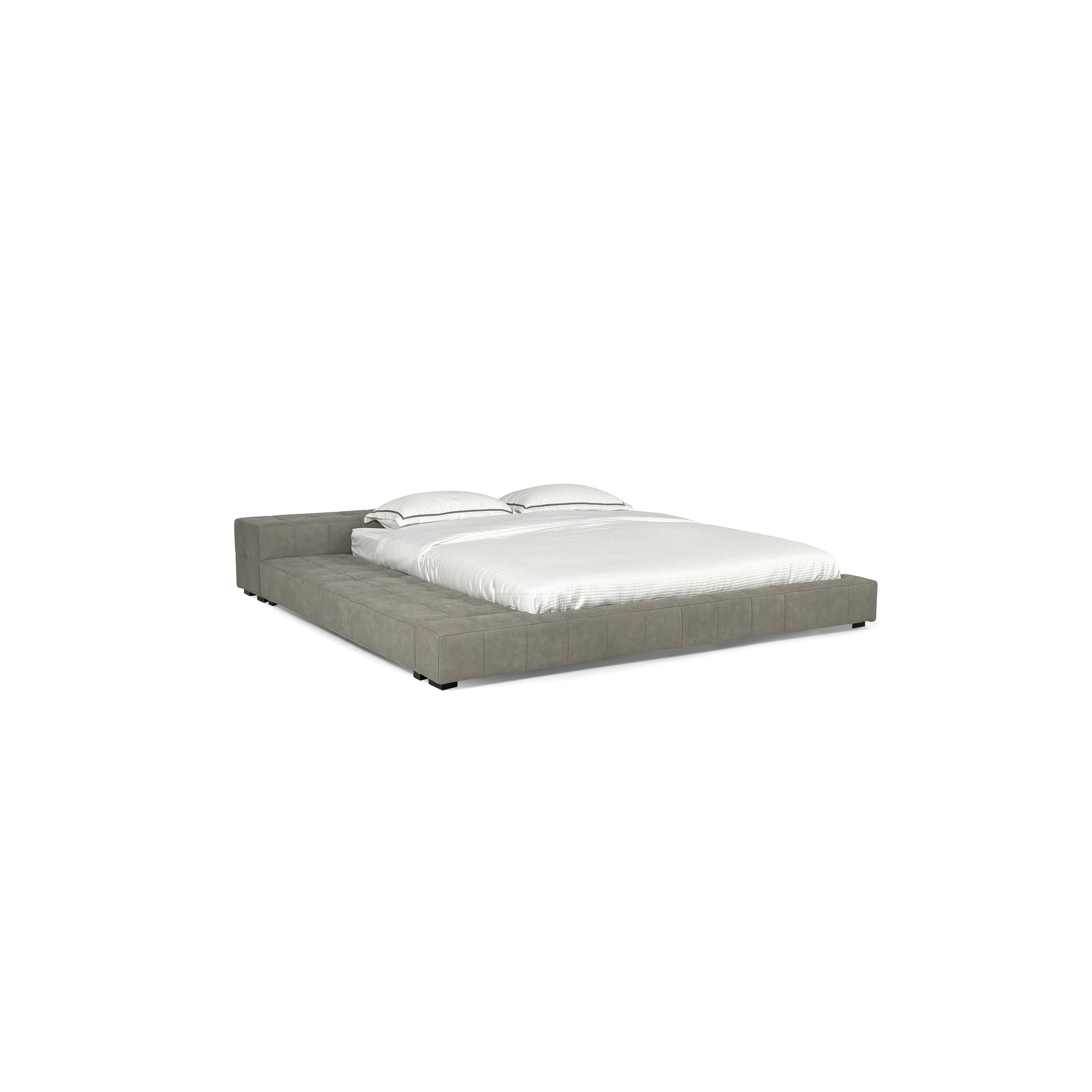 Low-profile platform bed with tufted gray upholstered frame, two matching pillows, and white bedding; features short black legs and continuous cushioned base; designed for sleeping; Category: Furniture > Beds > Platform Beds