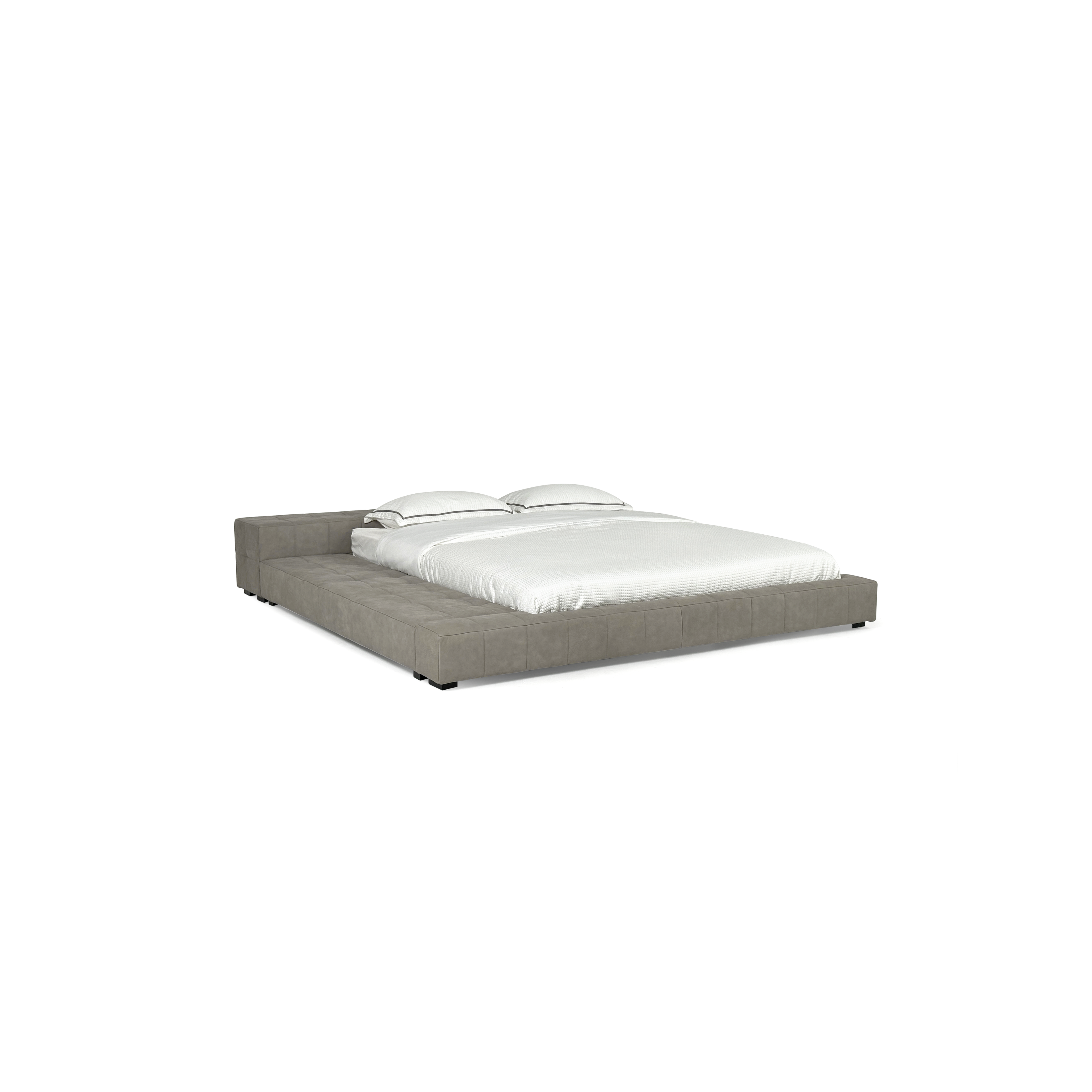 Low-profile platform bed with upholstered frame in gray fabric, featuring tufted surface, two pillows, and black feet; designed for sleeping, with minimalist rectangular form and no visible legs or armrests. Category: furniture > beds > platform beds