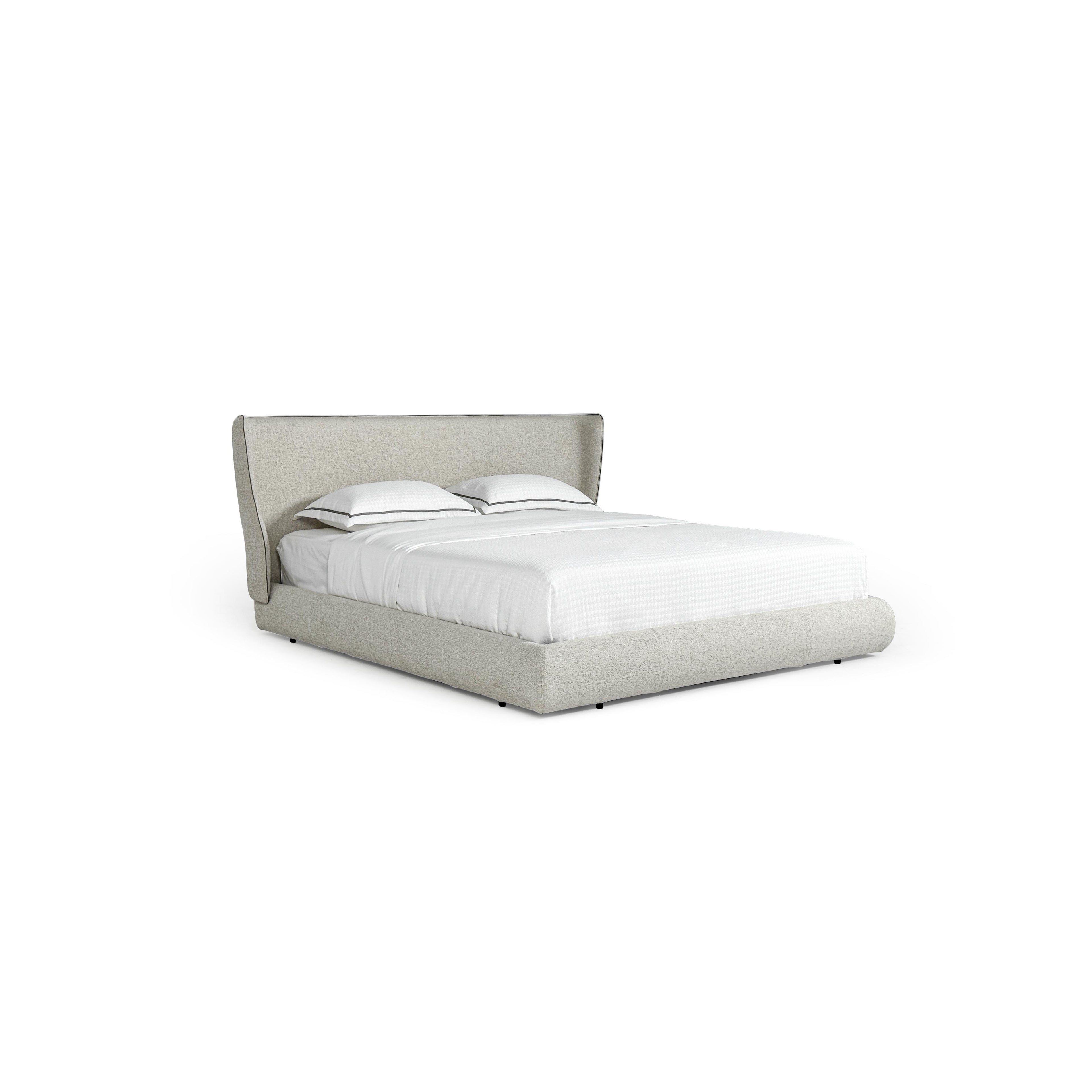 This upholstered bed features a low-profile frame with a padded headboard and base, covered in a light gray textured fabric. It includes two white pillows with dark trim and a white quilted mattress. Designed for sleeping, it has small black feet. Category: furniture > beds > upholstered beds