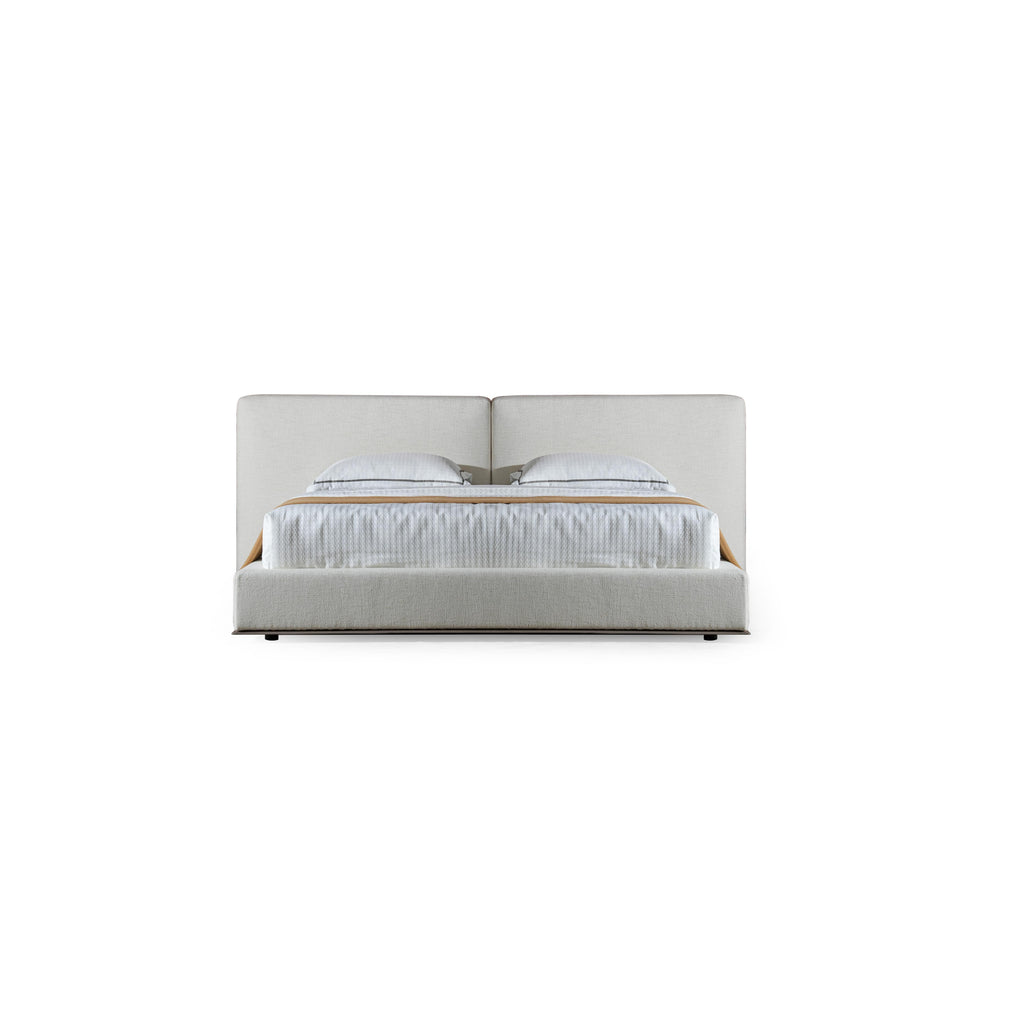 A upholstered bed with a low-profile frame and a continuous headboard, featuring two pillows and a textured white mattress with a tan throw. The base has dark legs and a fabric-covered structure. Category: furniture > beds > upholstered beds