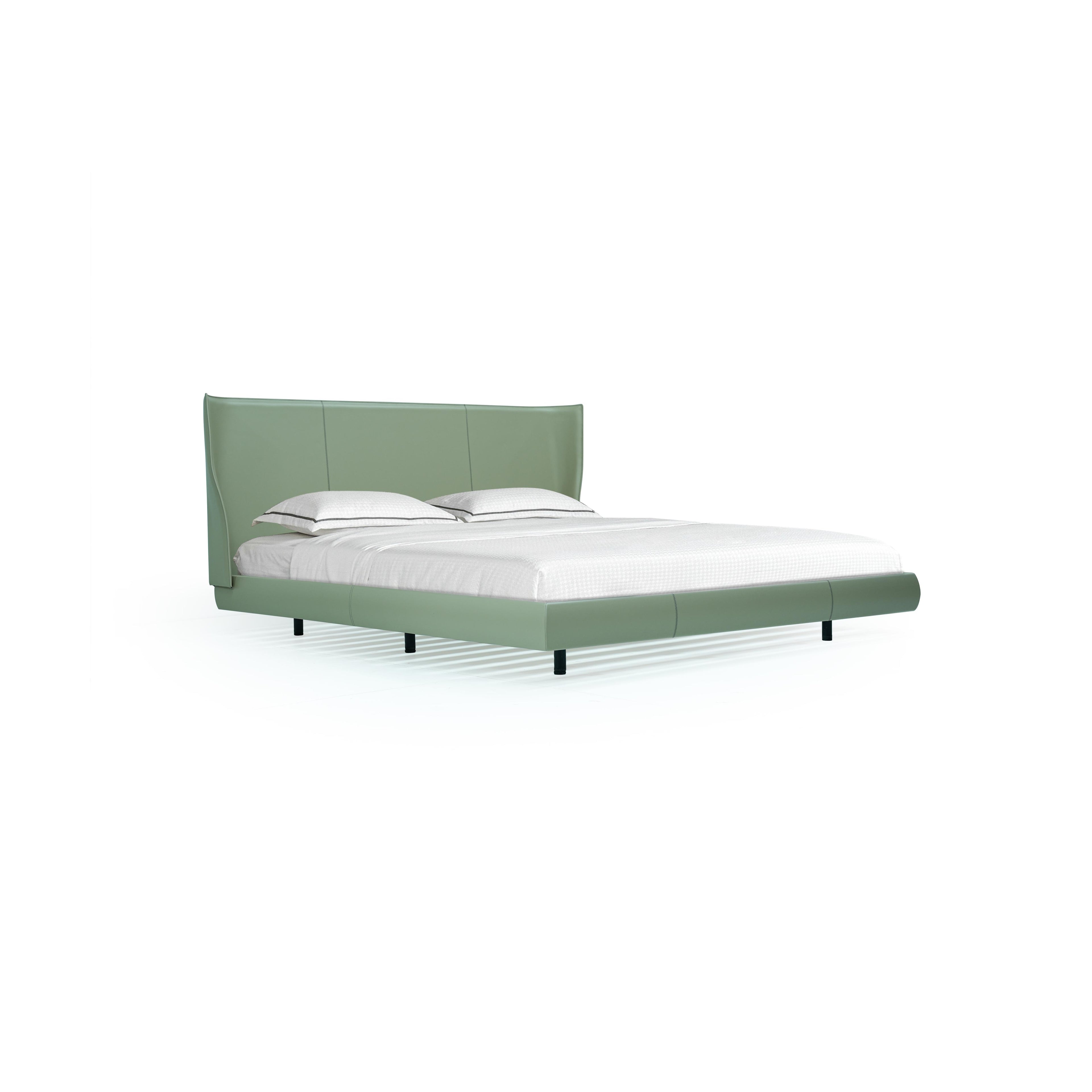 A modern bed with a sage green upholstered headboard and base, featuring two black legs, white pillows with dark piping, and a white mattress; designed for sleeping, with clean lines and stitched paneling on the frame. Category: furniture > beds > platform beds