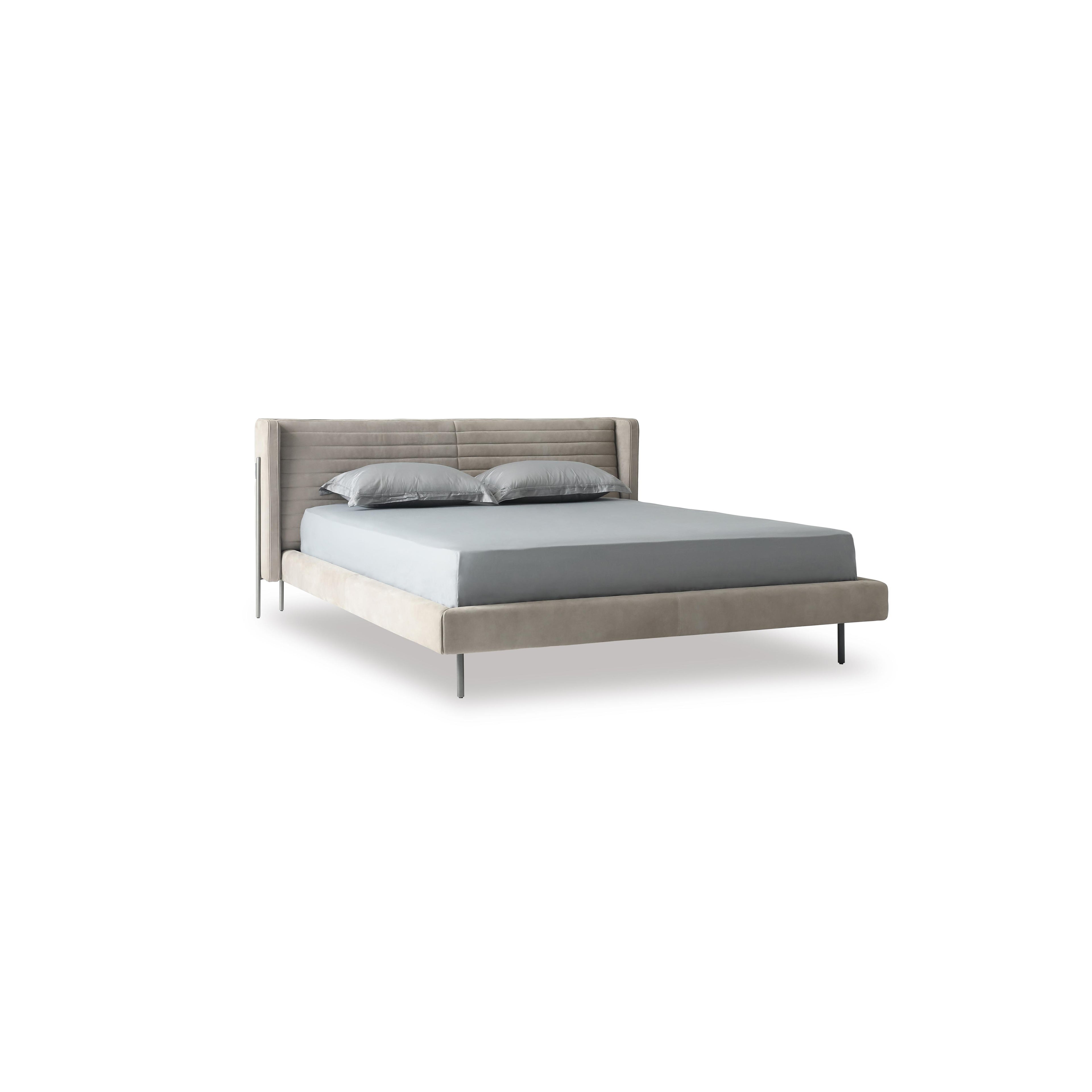 A modern bed with a gray upholstered headboard and base, supported by four thin black legs. It features a tufted backrest, layered pillows, and a satin-textured duvet. Designed for sleeping, it has a clean, minimalist silhouette with visible stitching along seams. Category: Furniture > Beds > Modern Beds