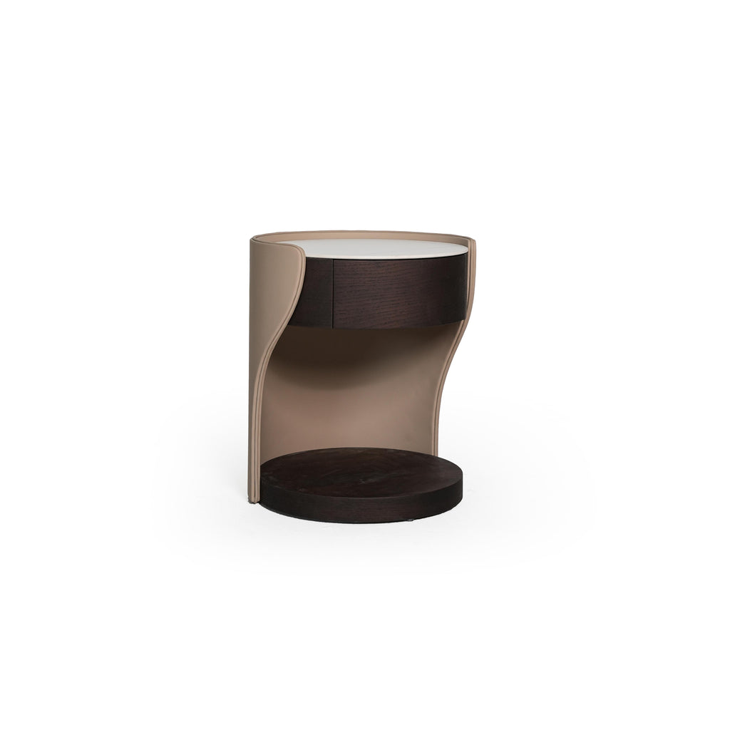 Round side table with a white top, dark wood drawer front, and a curved beige frame. Features a dark wood base and open interior. Designed for bedside or accent placement. Category: furniture/side-tables