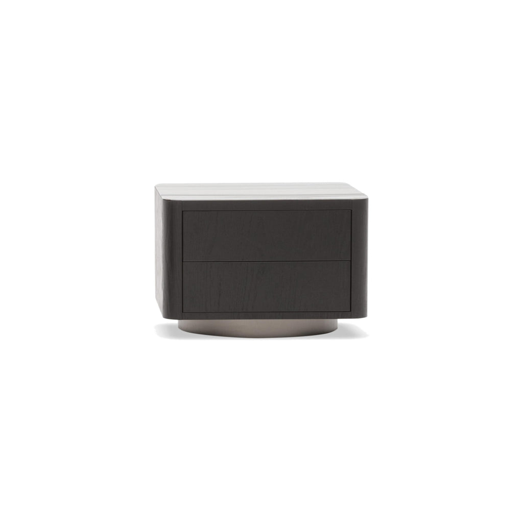 A two-drawer nightstand with a dark wood-grain finish and a light-colored top surface, supported by a circular metallic base. Features two flat drawers with no visible handles. Intended for bedside storage. Category: furniture/nightside-tables