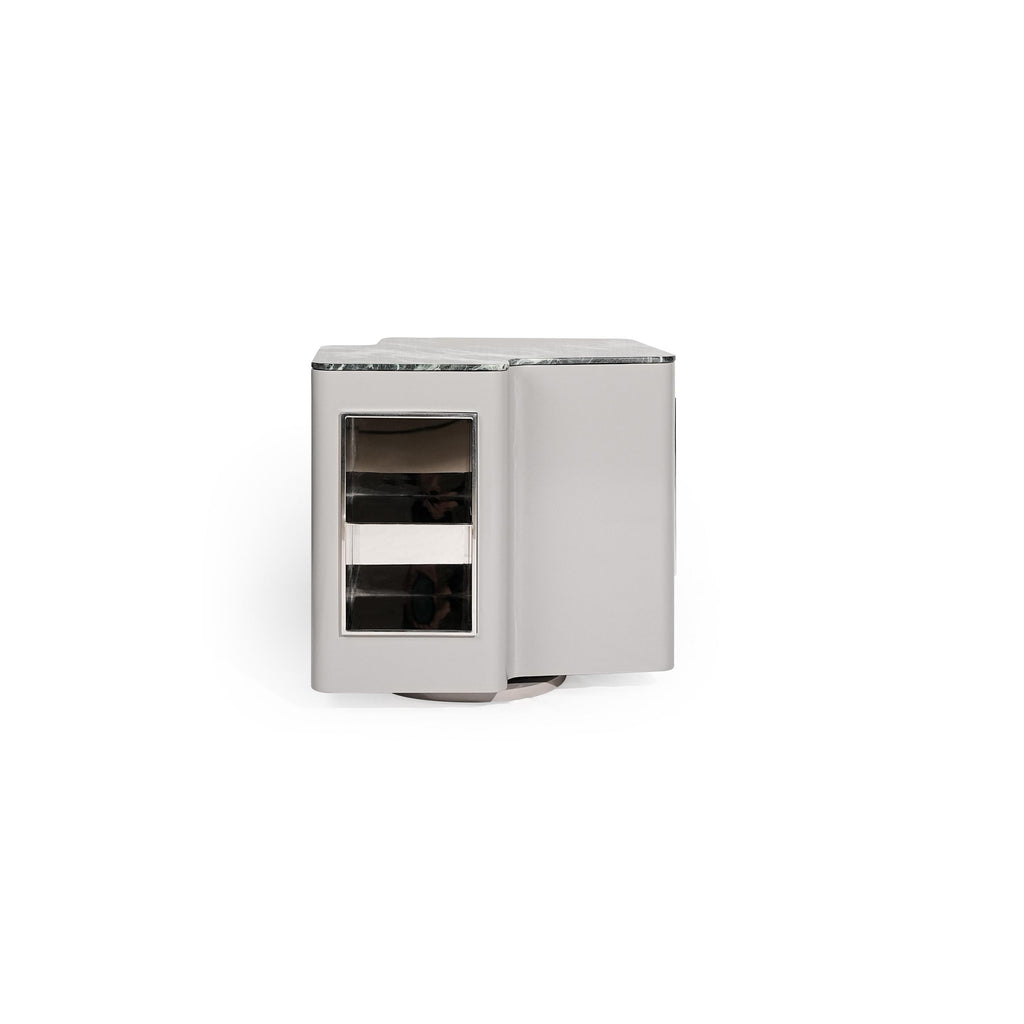 Modern side table with a rectangular form, featuring a gray marble top, a silver-finished frame, and a glass-fronted compartment with two horizontal shelves. It has a single visible door and a circular base. Intended for holding small items or as a decorative accent. Category: Furniture > Tables > Side Tables
