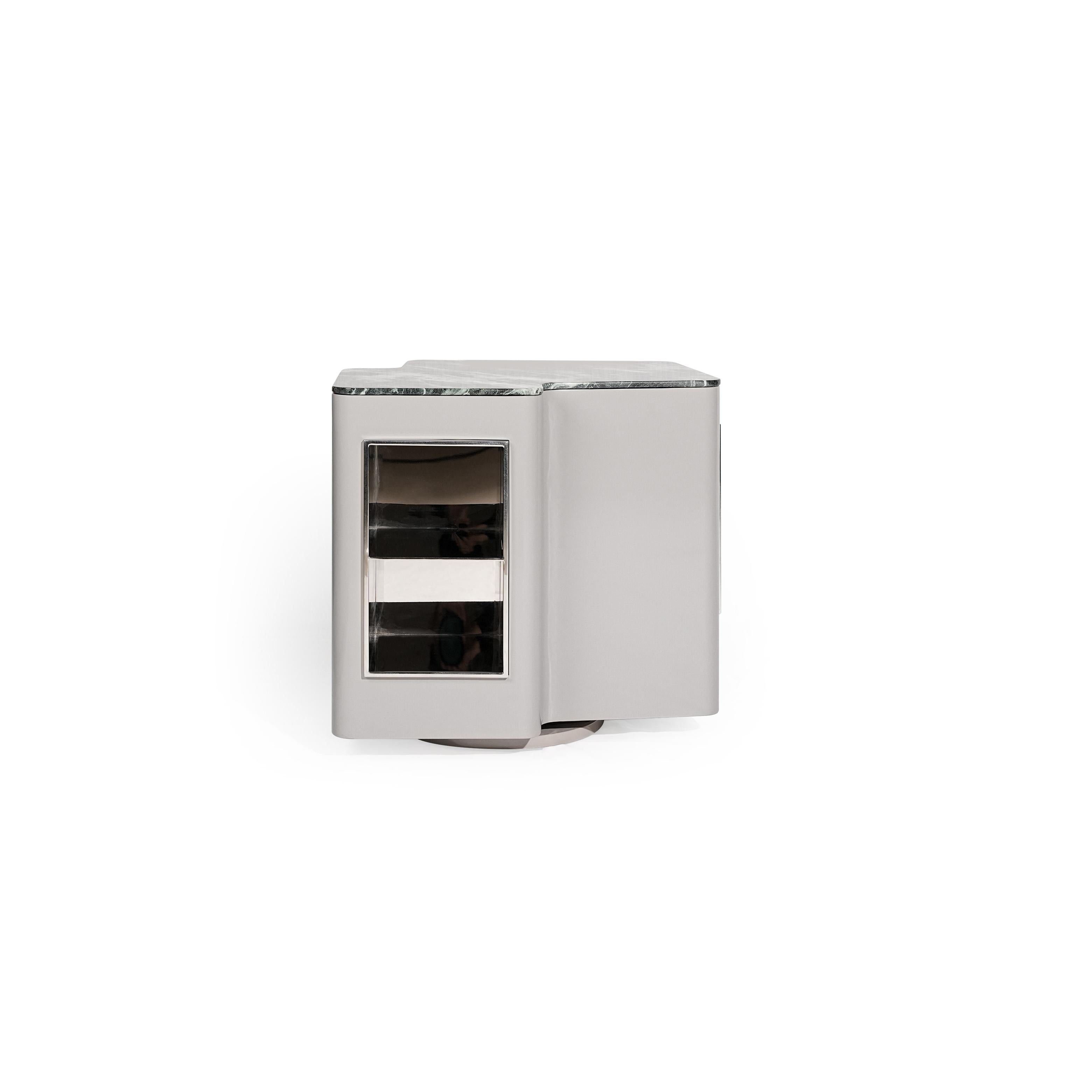 Modern side table with a rectangular form, featuring a gray marble top, a silver-finished frame, and a glass-fronted compartment with two horizontal shelves. It has a single visible door and a circular base. Intended for holding small items or as a decorative accent. Category: Furniture > Tables > Side Tables