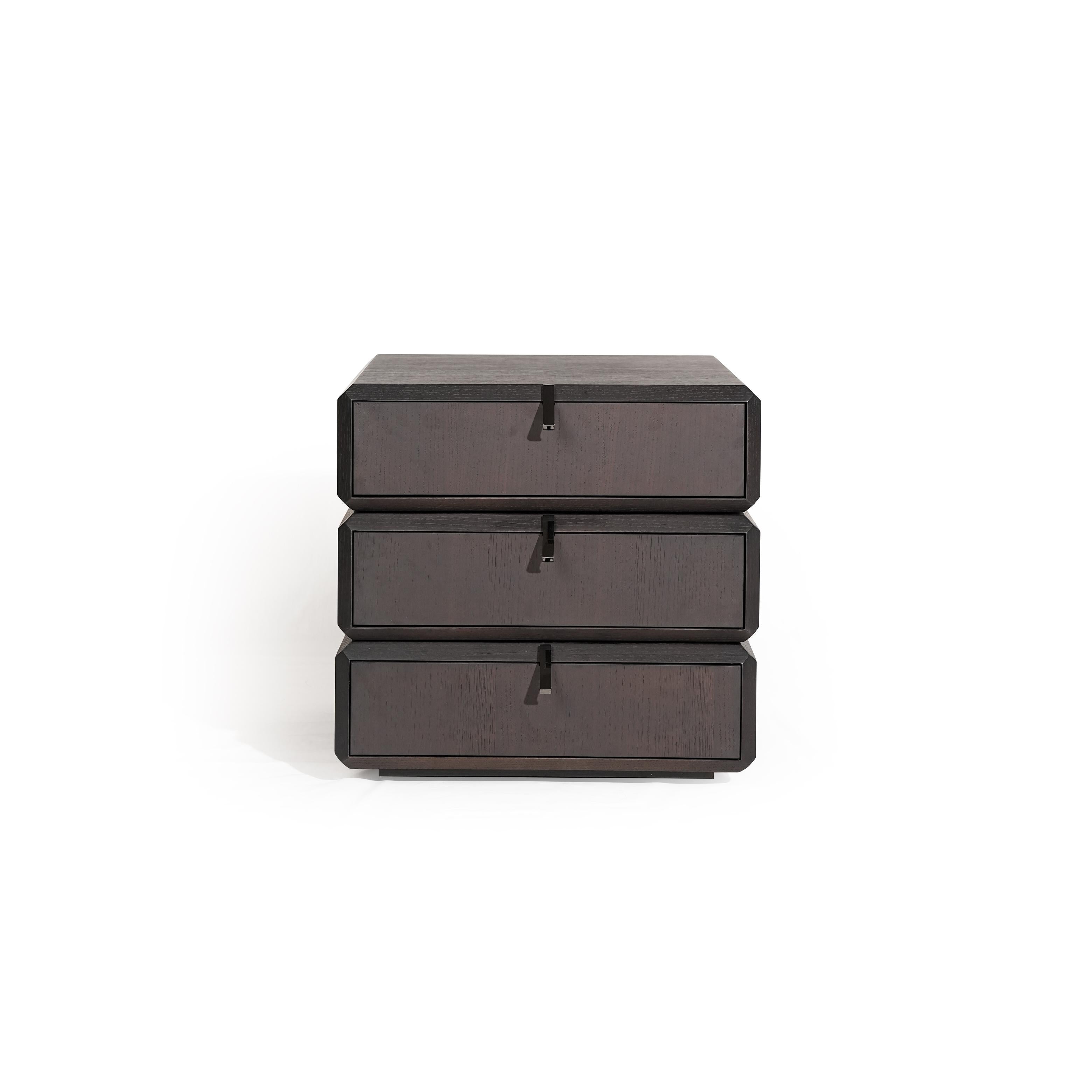 Three-drawer nightstand with dark wood finish and visible grain, each drawer fitted with a black metal pull handle; compact, stacked rectangular form; intended for bedside storage; Category: furniture > bedroom > nightstands