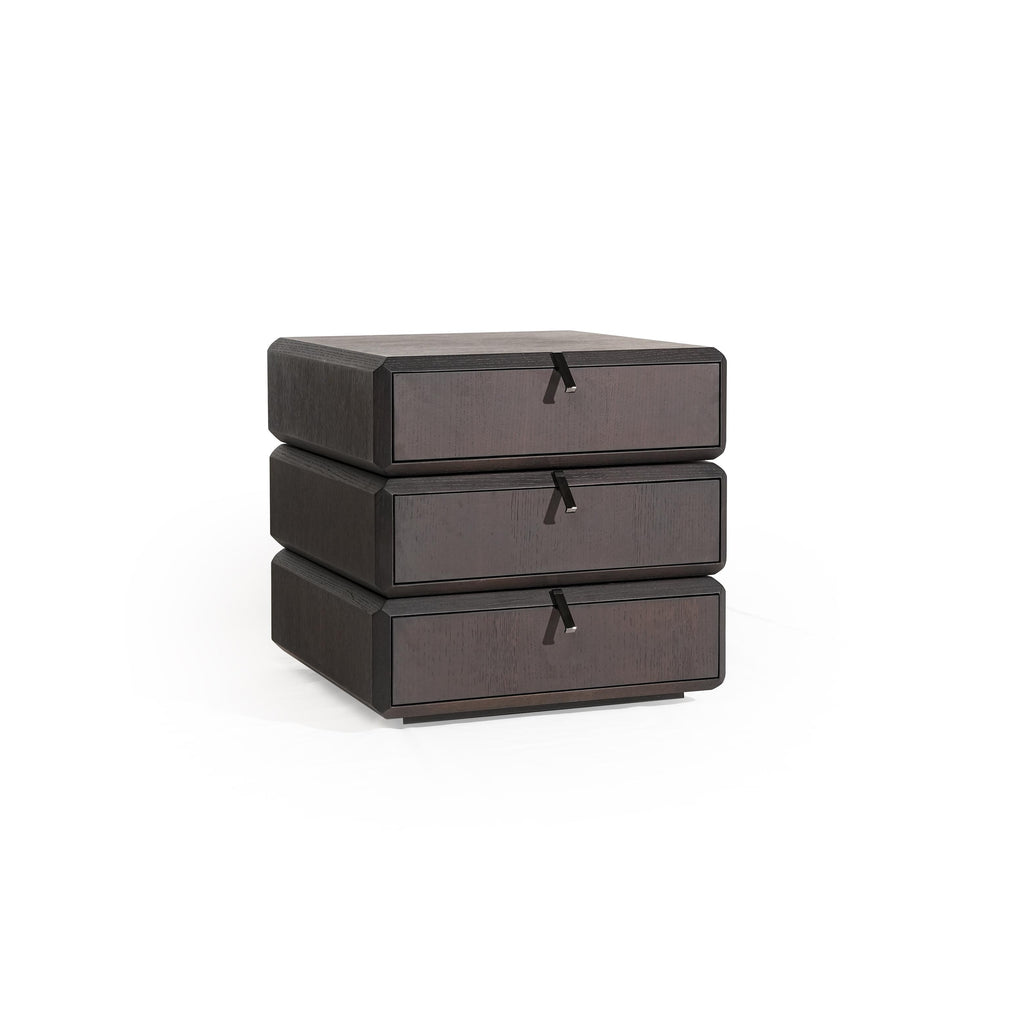 Three-drawer nightstand with dark wood finish and visible grain, each drawer fitted with a black metal pull handle; compact, stacked rectangular form; intended for bedside storage; Category: furniture > bedroom > nightstands