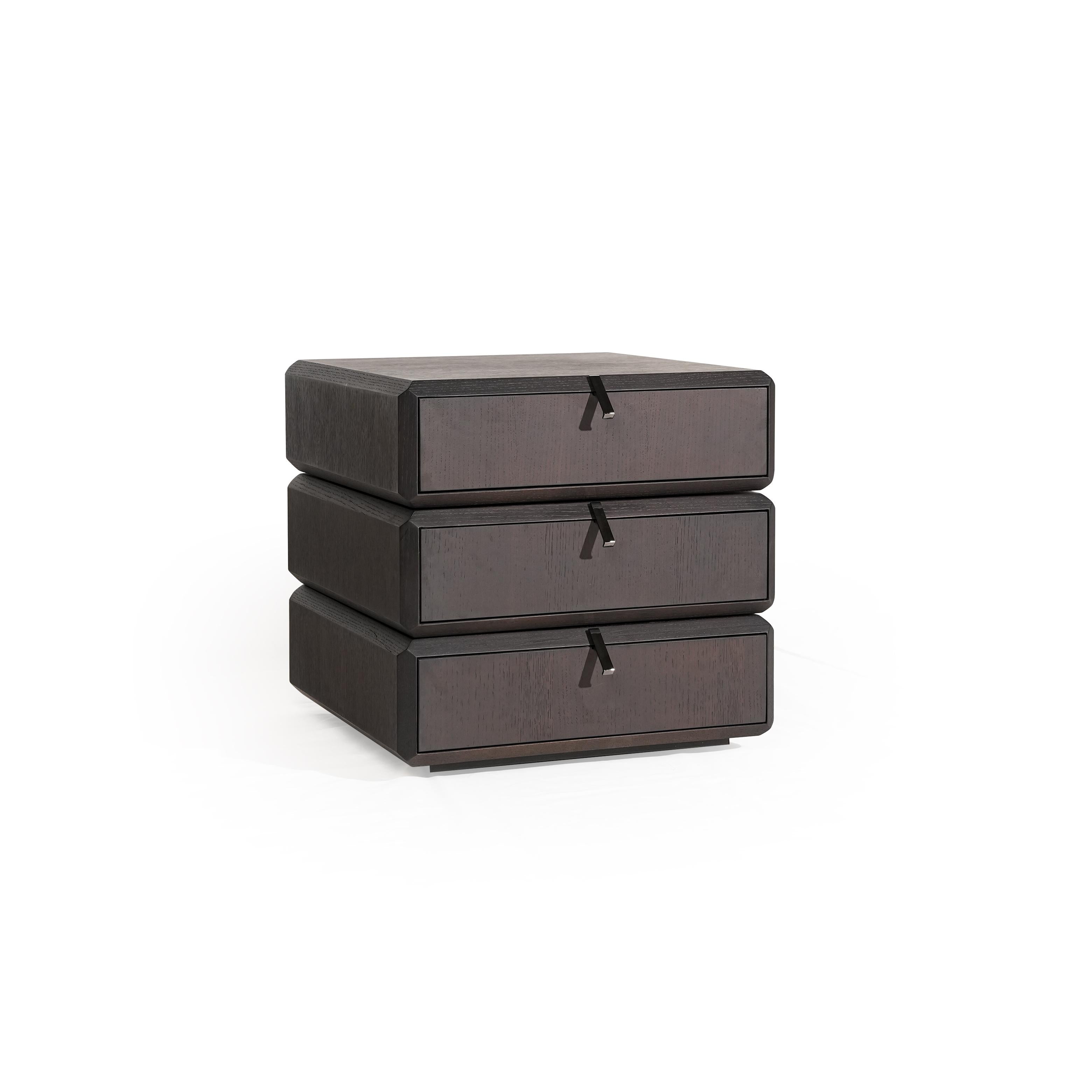Three-drawer nightstand with dark wood finish and visible grain, each drawer fitted with a black metal pull handle; compact, stacked rectangular form; intended for bedside storage; Category: furniture > bedroom > nightstands