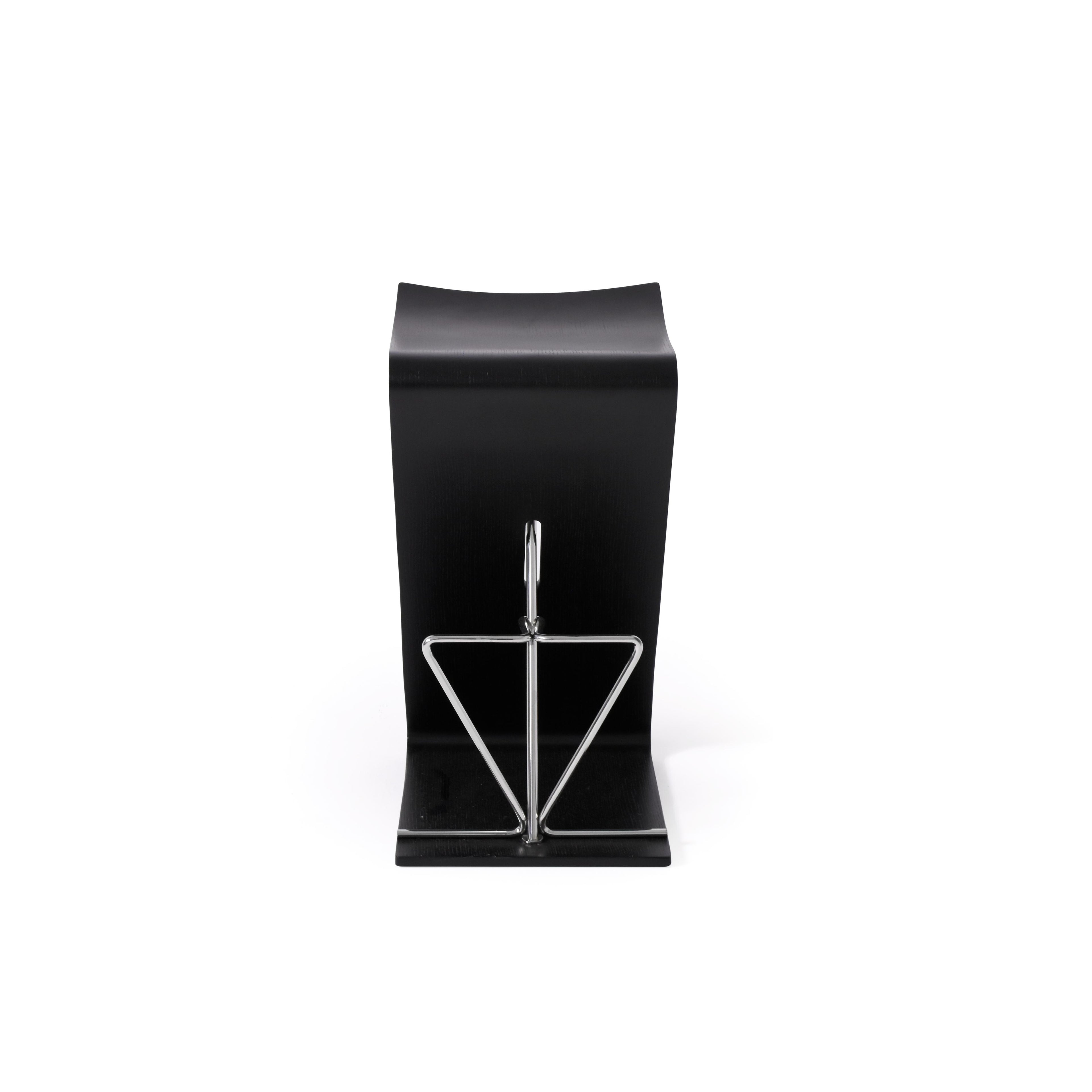 Black bookend with a matte finish and a triangular metal frame for holding books. The base is flat and wide for stability. The metal frame has a reflective surface. Intended for organizing books on shelves. Category: furniture/bookshelves