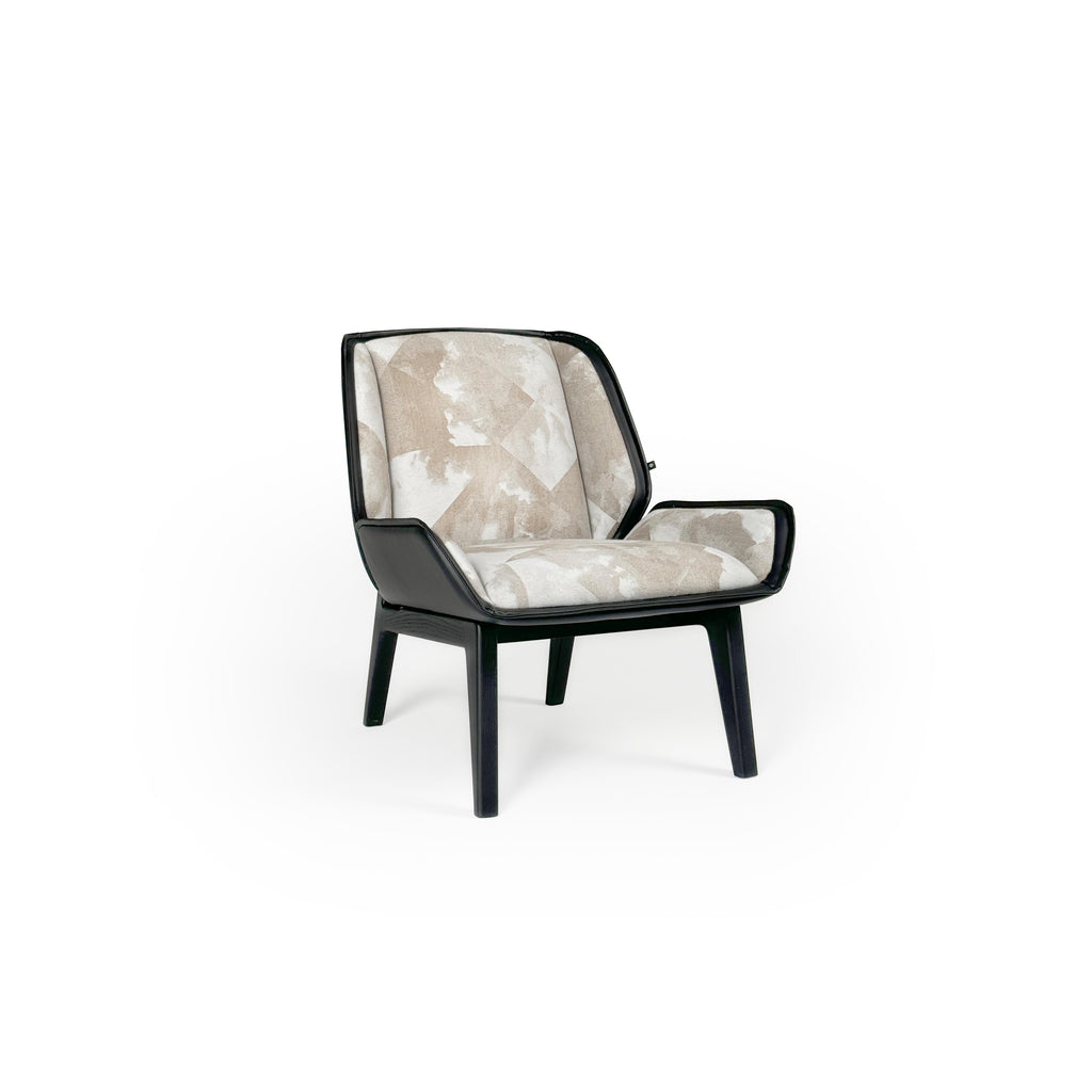 Armchair with upholstered seat and backrest in beige and white abstract pattern, framed by black leather-like trim. Four tapered legs support the structure. Designed for seated comfort in living or reading areas. Category: furniture/chairs/armchairs