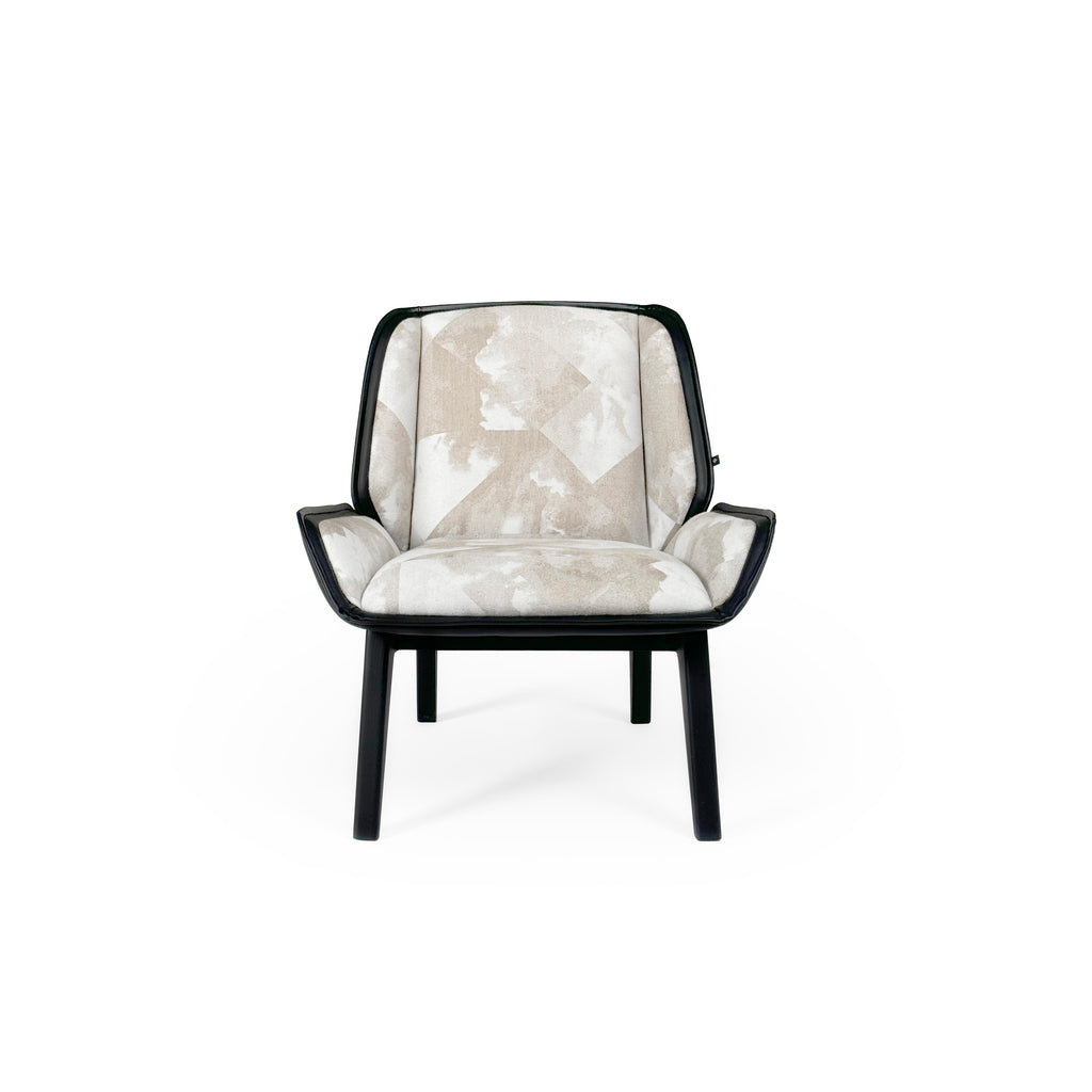 Armchair with upholstered seat and backrest in beige and white abstract pattern, framed by black leather-like trim. Four tapered legs support the structure. Designed for seated comfort in living or reading areas. Category: furniture/chairs/armchairs