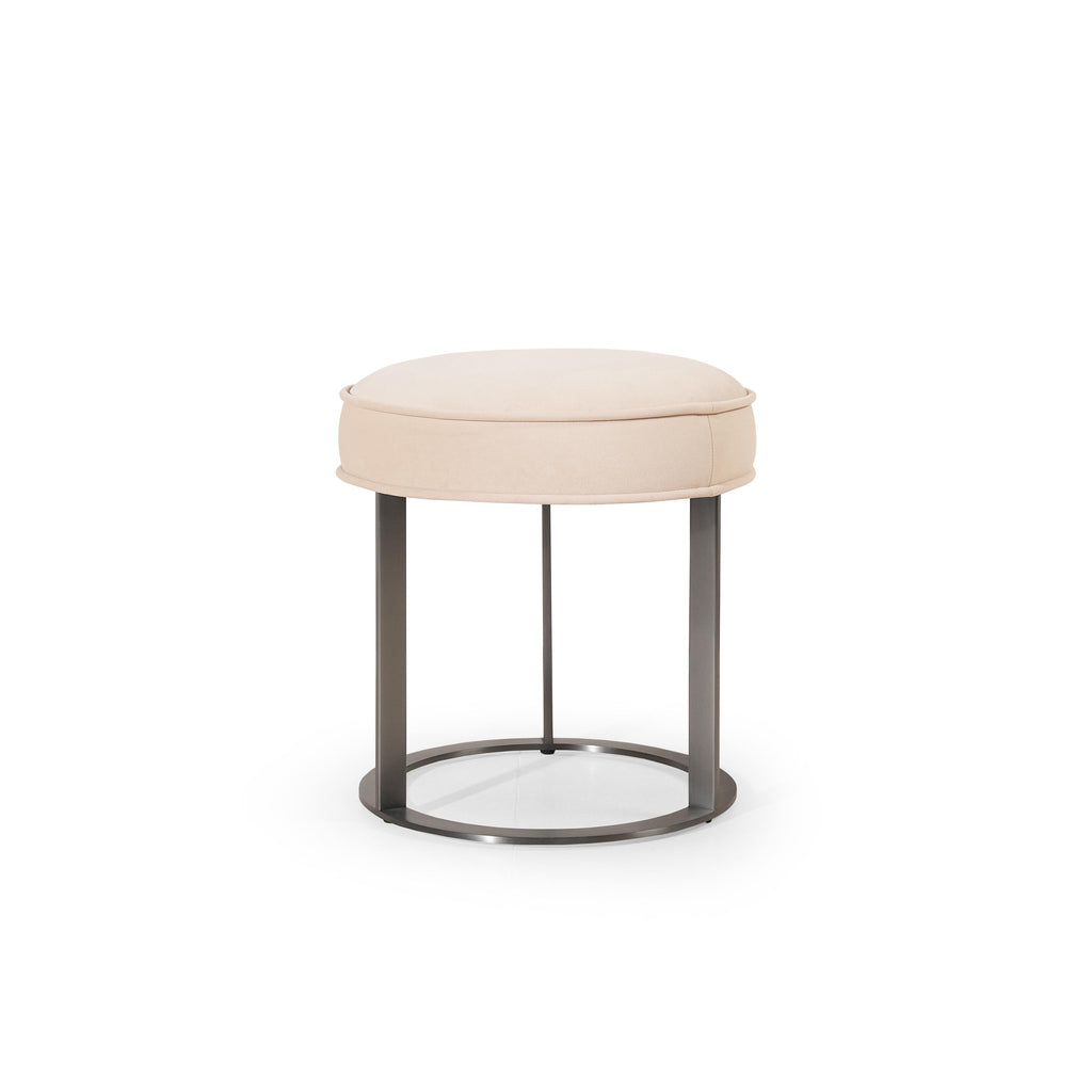 Round upholstered stool with light beige fabric seat and dark metal frame, featuring four vertical legs and a circular base ring; designed for seating or as a small side table; no visible handles, drawers, or fasteners; fabric appears smooth with subtle stitching along edges. Category: Furniture > Stools