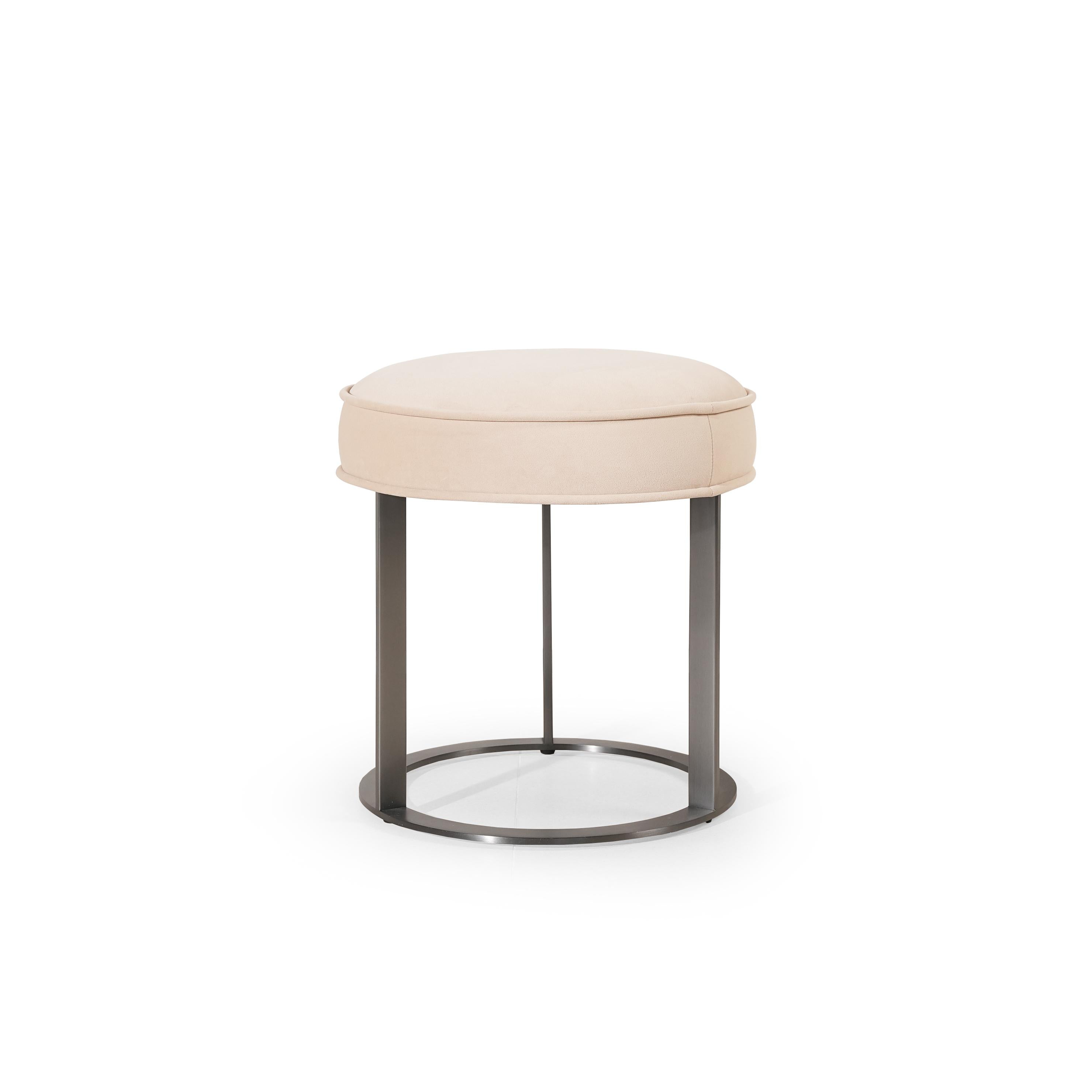 Round upholstered stool with light beige fabric seat and dark metal frame, featuring four vertical legs and a circular base ring; designed for seating or as a small side table; no visible handles, drawers, or fasteners; fabric appears smooth with subtle stitching along edges. Category: Furniture > Stools