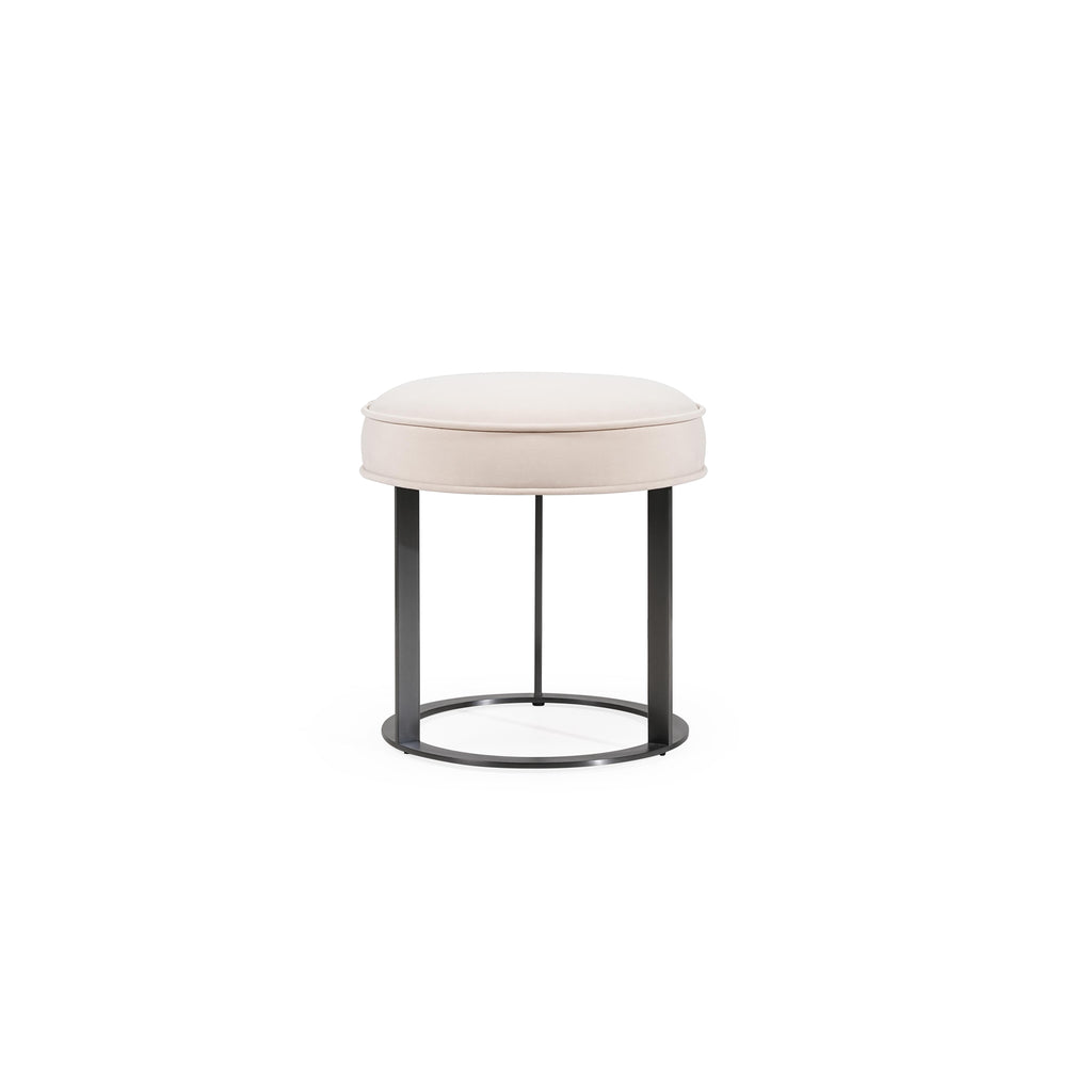 Round upholstered stool with light beige fabric seat and dark metal frame, featuring four vertical legs and a circular base ring; designed for seating or as a small side table; no visible handles, drawers, or fasteners; fabric appears smooth with subtle stitching along edges. Category: Furniture > Stools