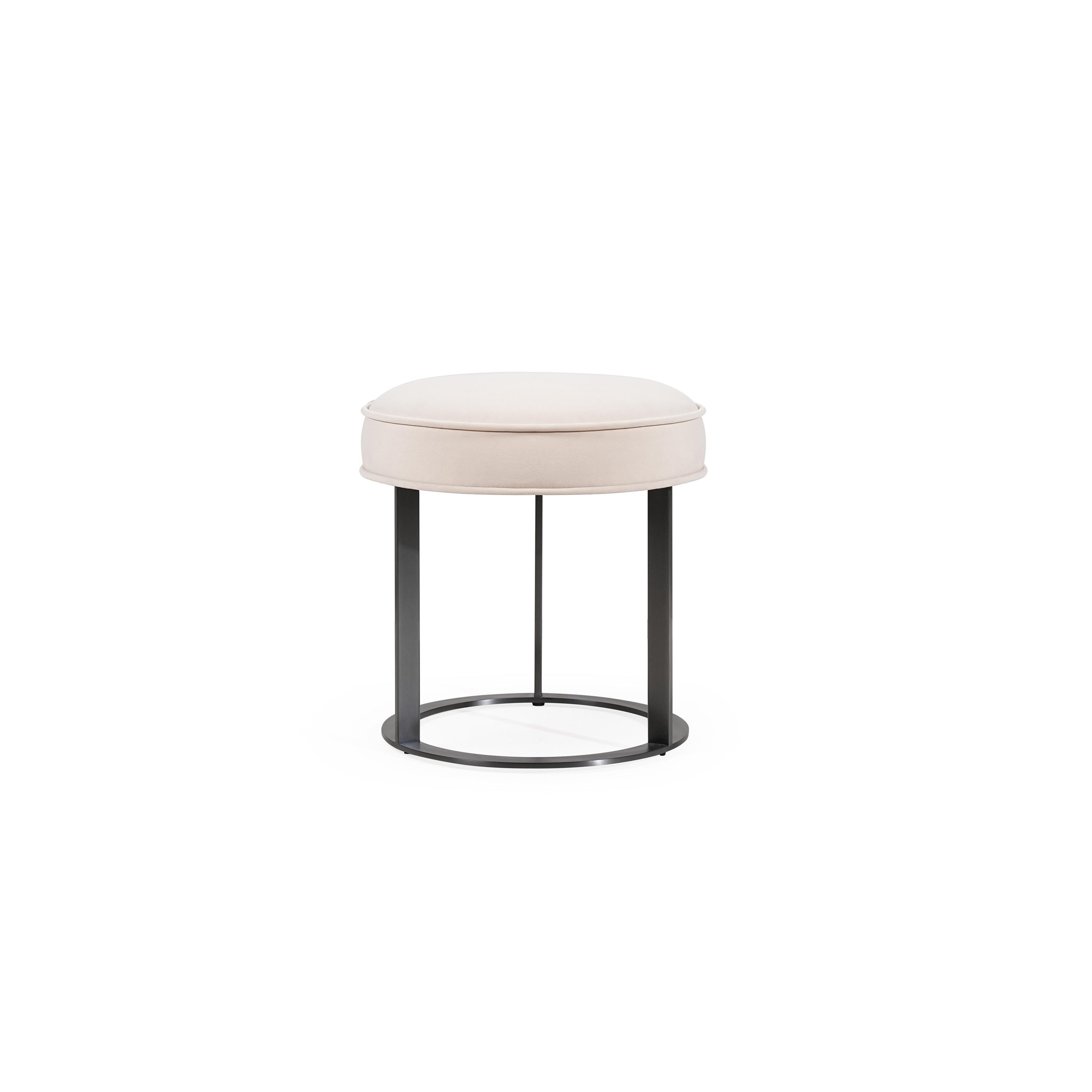 Round upholstered stool with light beige fabric seat and dark metal frame, featuring four vertical legs and a circular base ring; designed for seating or as a small side table; no visible handles, drawers, or fasteners; fabric appears smooth with subtle stitching along edges. Category: Furniture > Stools