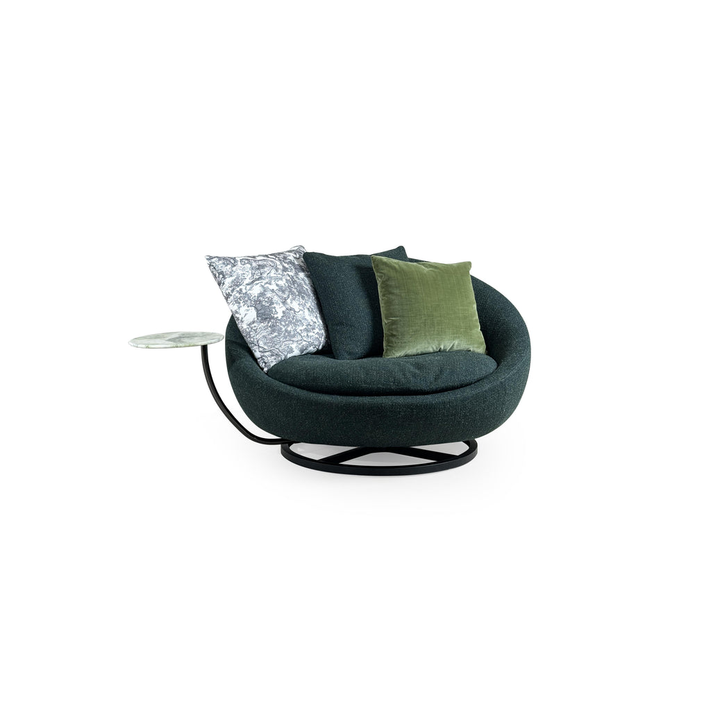 Circular swivel lounge chair with dark green textured fabric upholstery, black metal base with X-shaped support, and integrated side table with light green marble top; features three cushions including one with gray and white pattern and one solid olive green; designed for seated relaxation and casual use. Category: Furniture > Sofas & Sectionals > Lounge Chairs