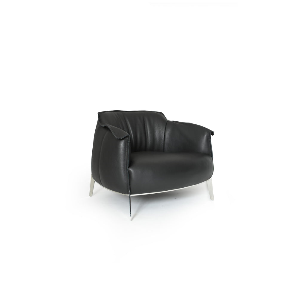 Black leather-like upholstered armchair with curved backrest, padded arms, and a rounded seat supported by four slender metallic legs; designed for seated comfort in living or lounge areas. Category: furniture/armchairs